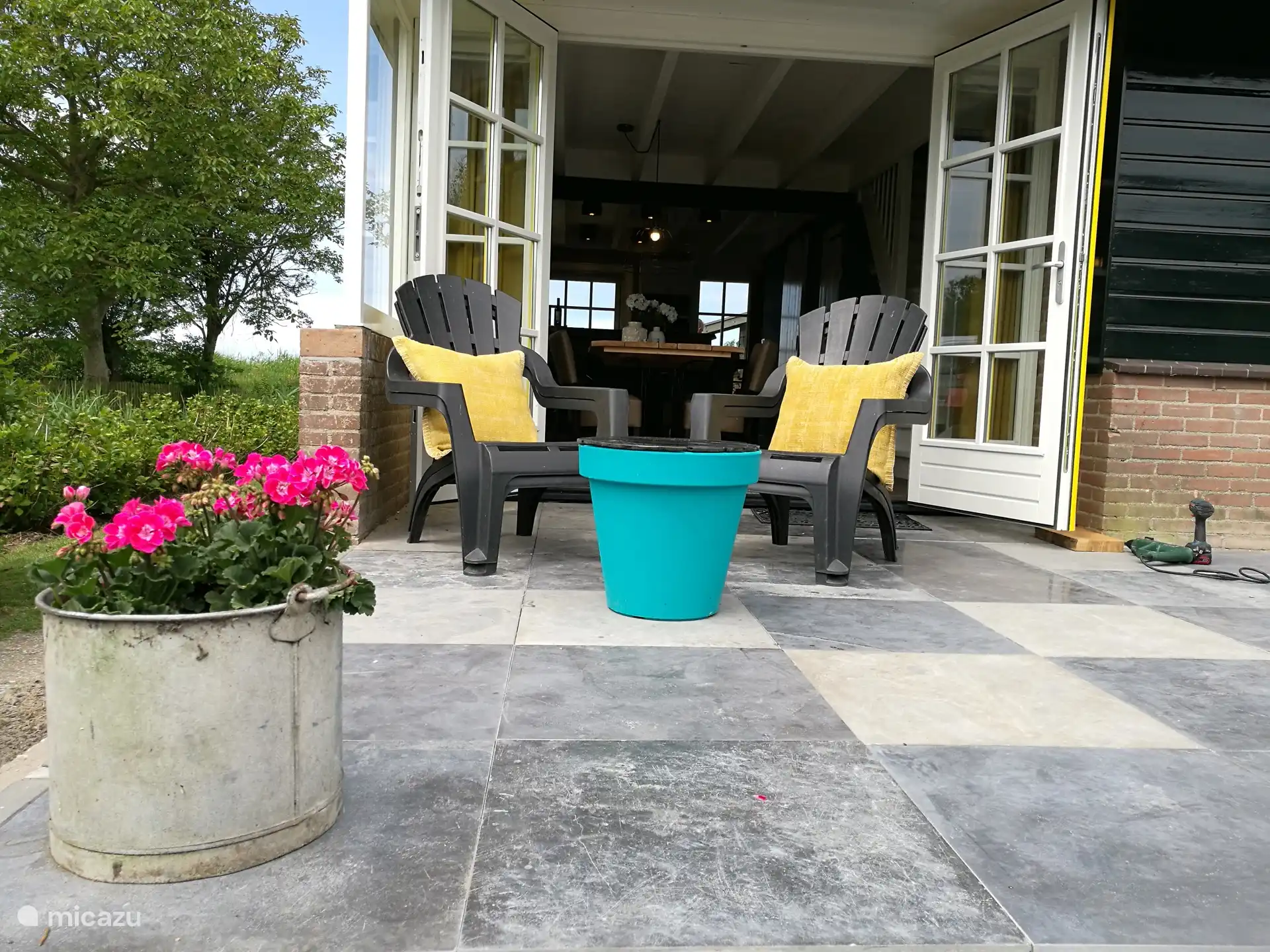 Geniet van het zonnige terras met uitzicht op de speeltuin