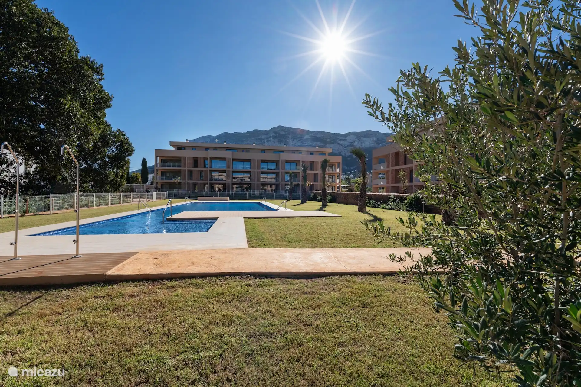 View of apartments block with beautiful swimming pool and complex garden 