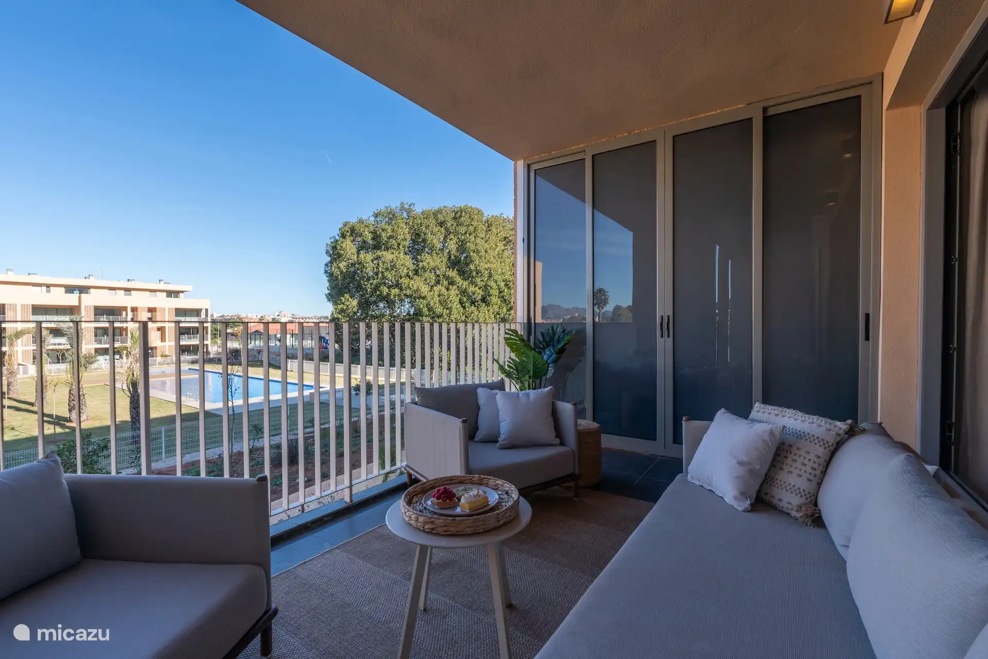 Balcony with lounge set, and behind the sliding wall a washing machine