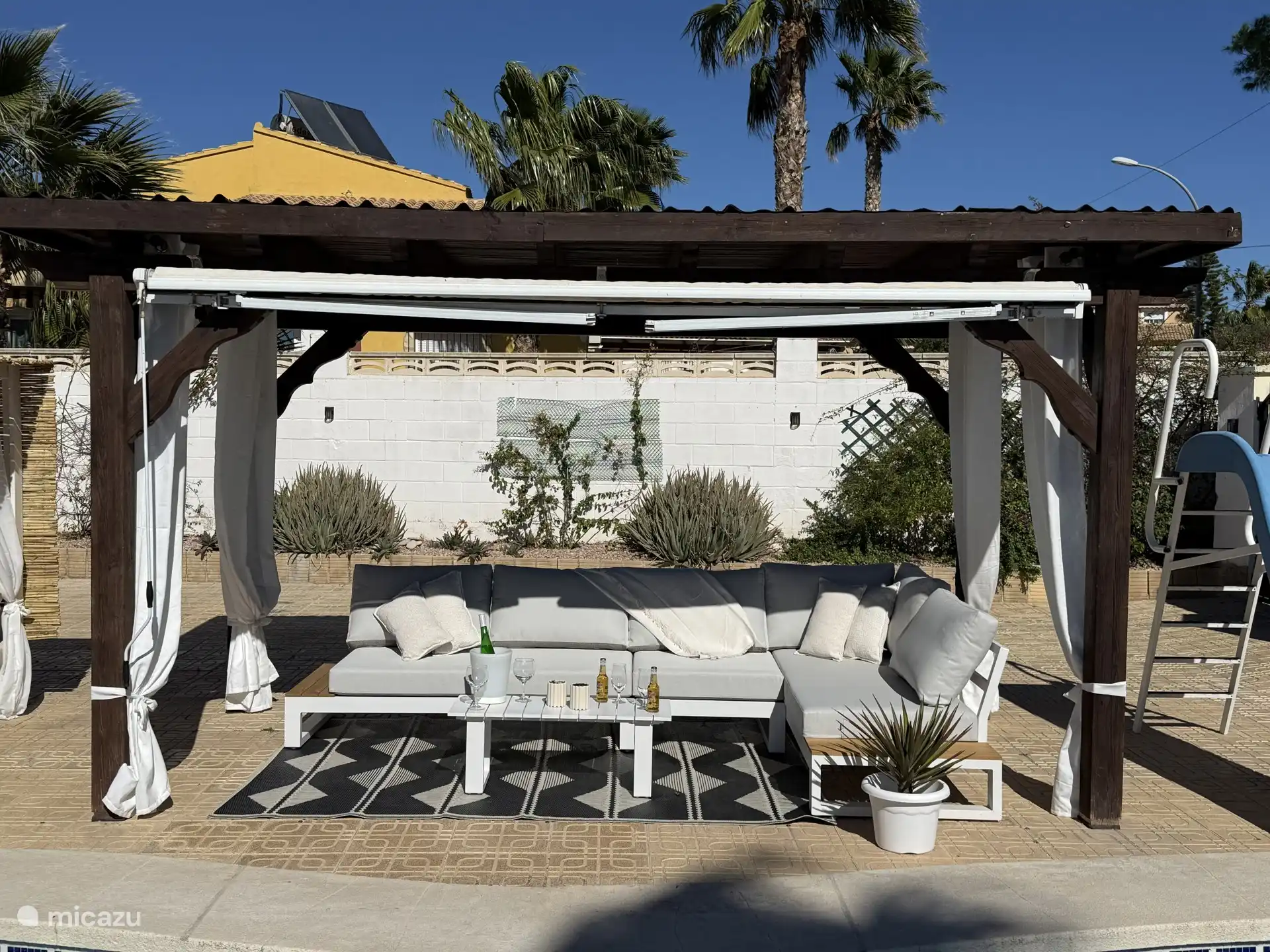 Lounge set onder de veranda bij het zwembad