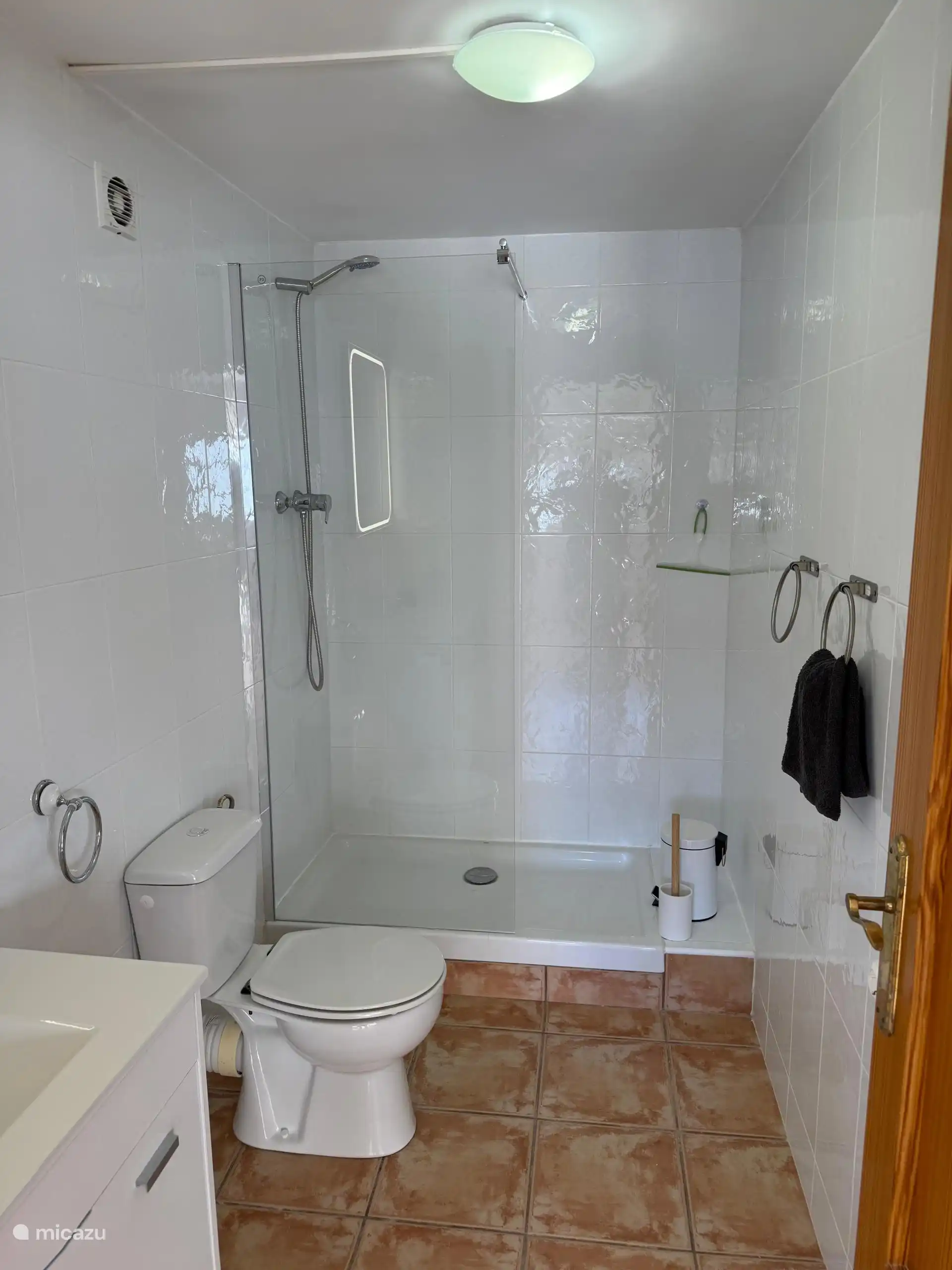 De badkamer is voorzien van een douche, toilet en wastafel met verwarmde spiegel tegen het beslaan.