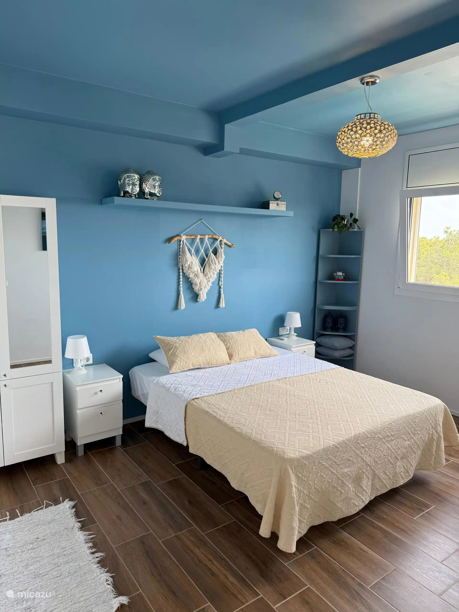 Blauwe slaapkamer appartement met uitzicht op tuin en de zee. Airco, horren, rolscherm en ensuit badkamer