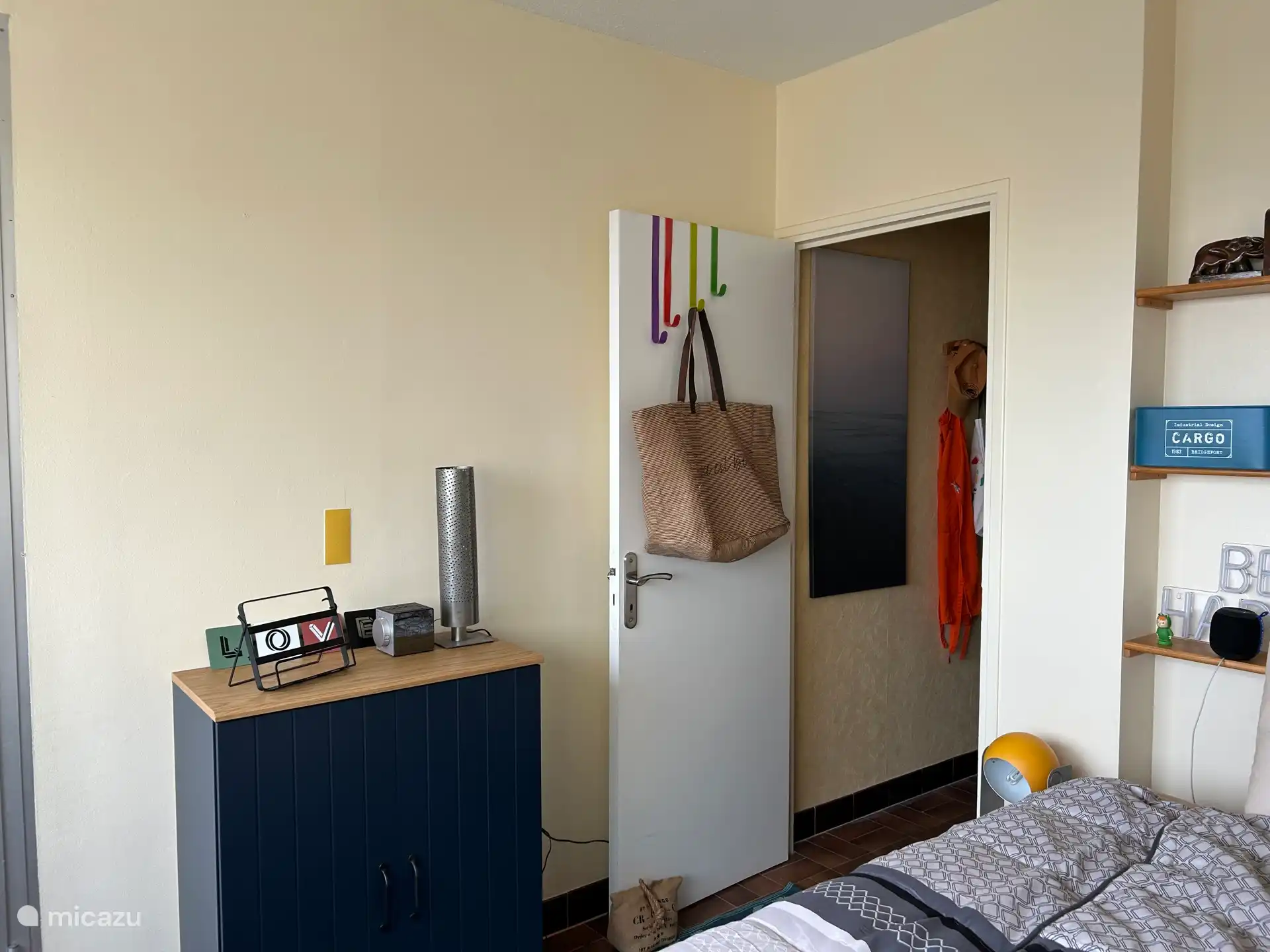 Chambre avec radio, réveil et placard.