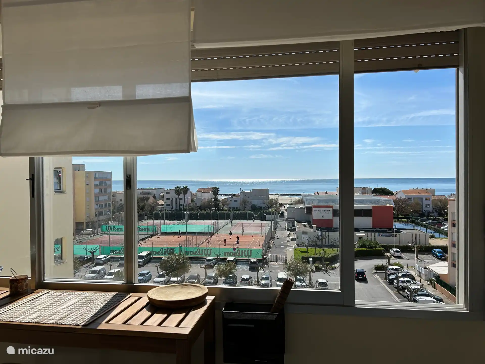 Vue depuis la chambre avec la table au coucher de soleil, 2 tabourets de bar