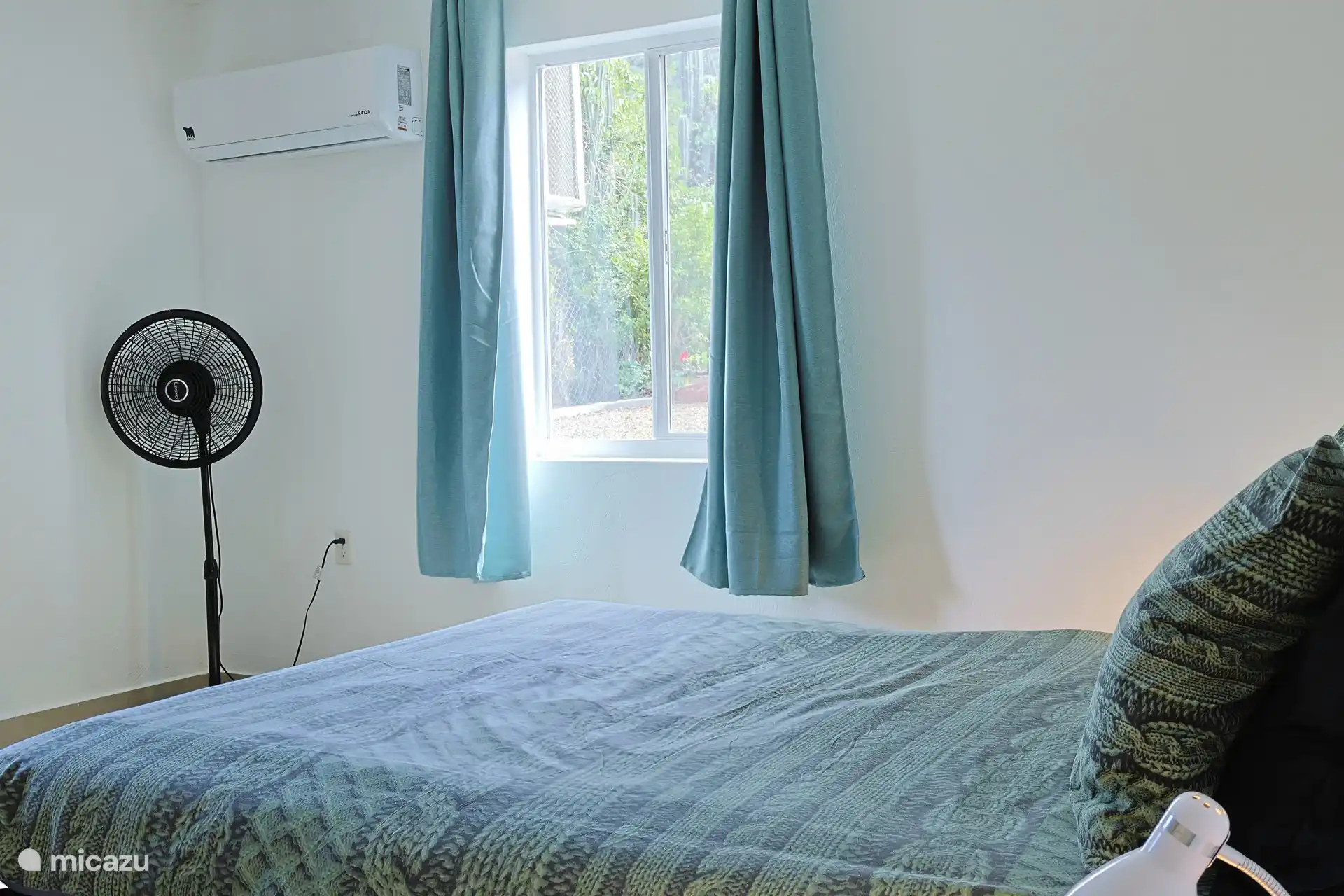 Master bedroom met airconditioning, fan en opbergruimte.