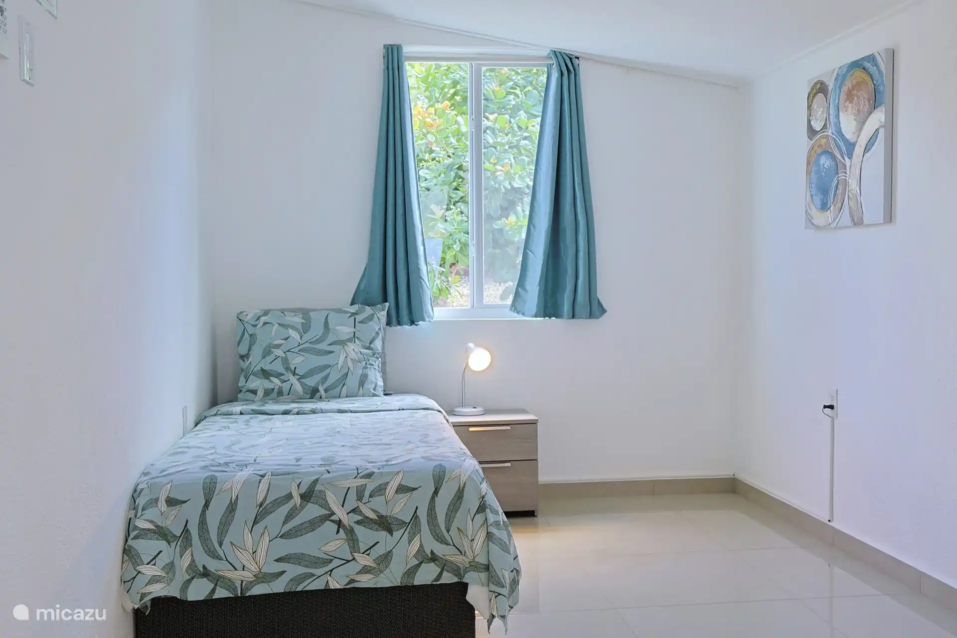 Slaapkamer met twee eenpersoons bedden, airconditioning, opbergruimte en fan.