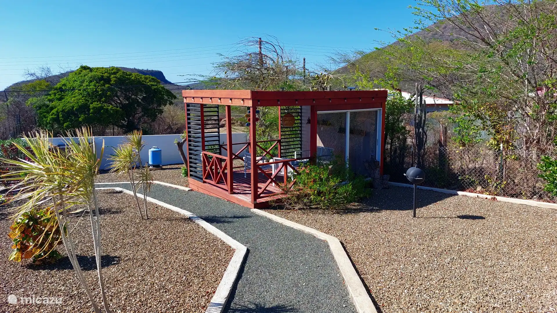 Buiten vind je meerdere zitplekken, waardoor je op elk moment van de dag kunt genieten van de tropische omgeving.