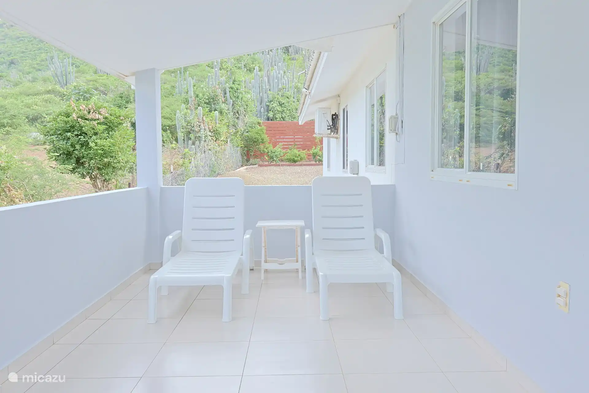 Buiten vind je meerdere zitplekken, waardoor je op elk moment van de dag kunt genieten van de tropische omgeving.