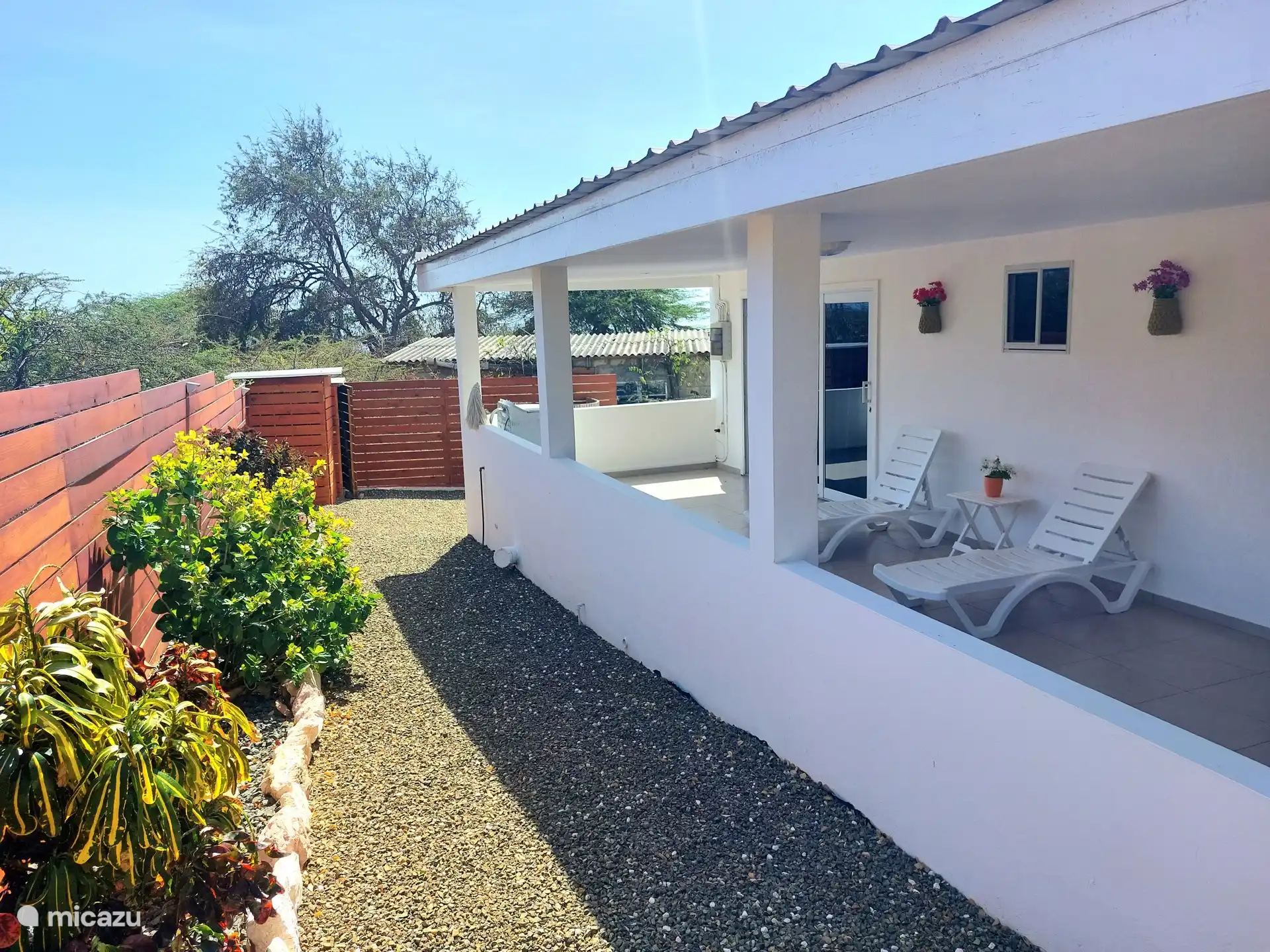 Buiten vind je meerdere zitplekken, waardoor je op elk moment van de dag kunt genieten van de tropische omgeving.