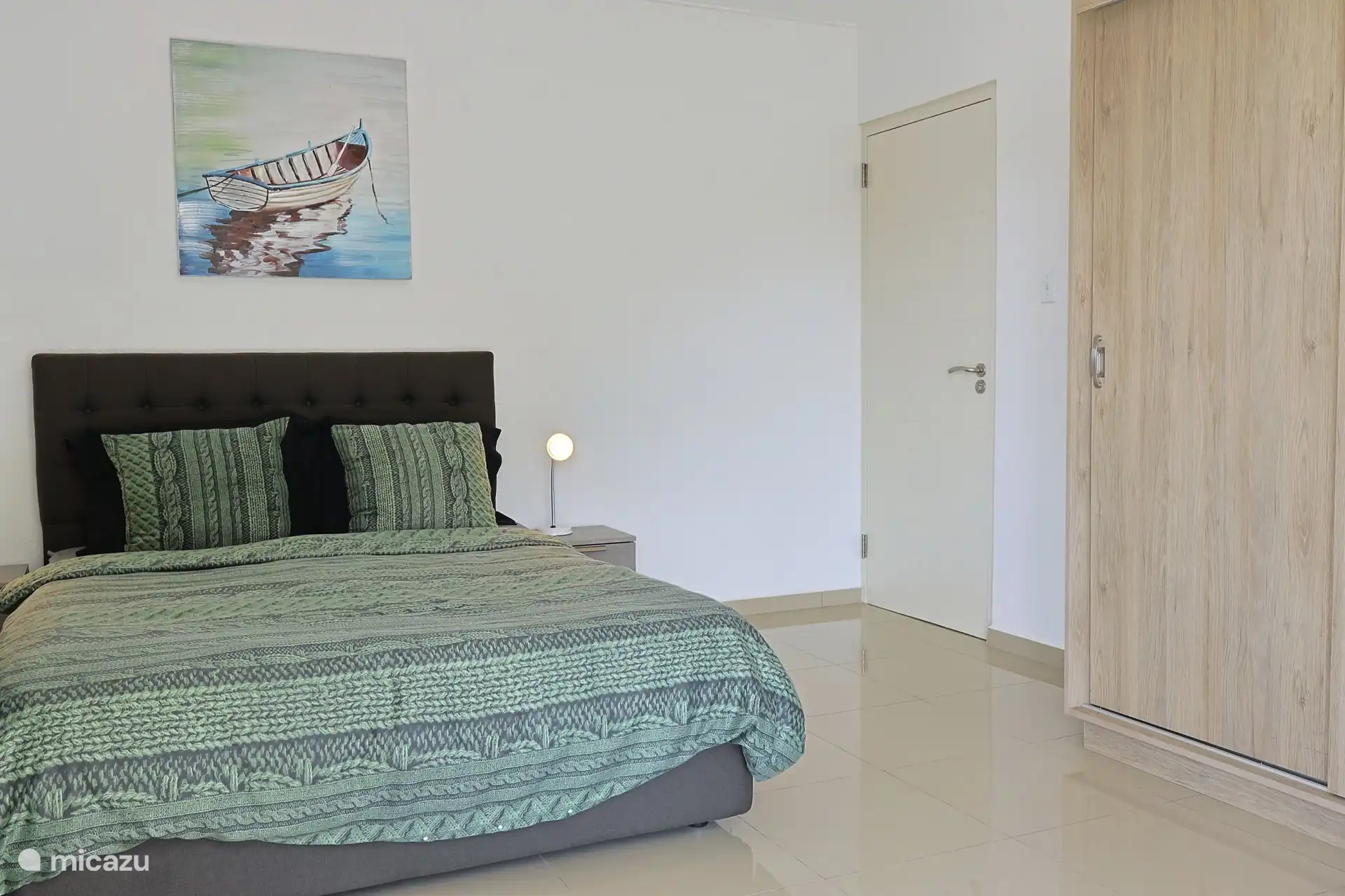 Master bedroom met airconditioning, opbergruimte en openslaande deuren naar het balkon.