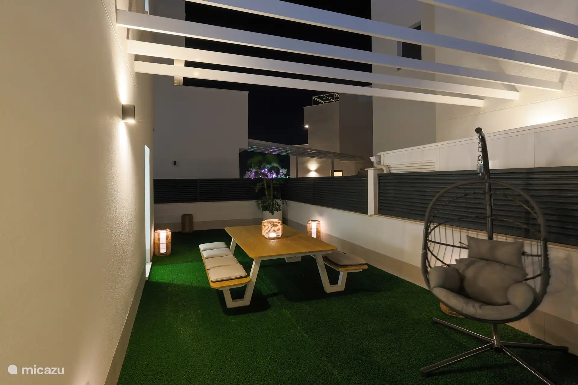 Jardín con una iluminación atractiva – Disfruta del jardín bellamente iluminado por la tarde. Para los niños hay un acogedor banco de picnic, perfecto para comer, jugar o disfrutar juntos del aire libre en Español.