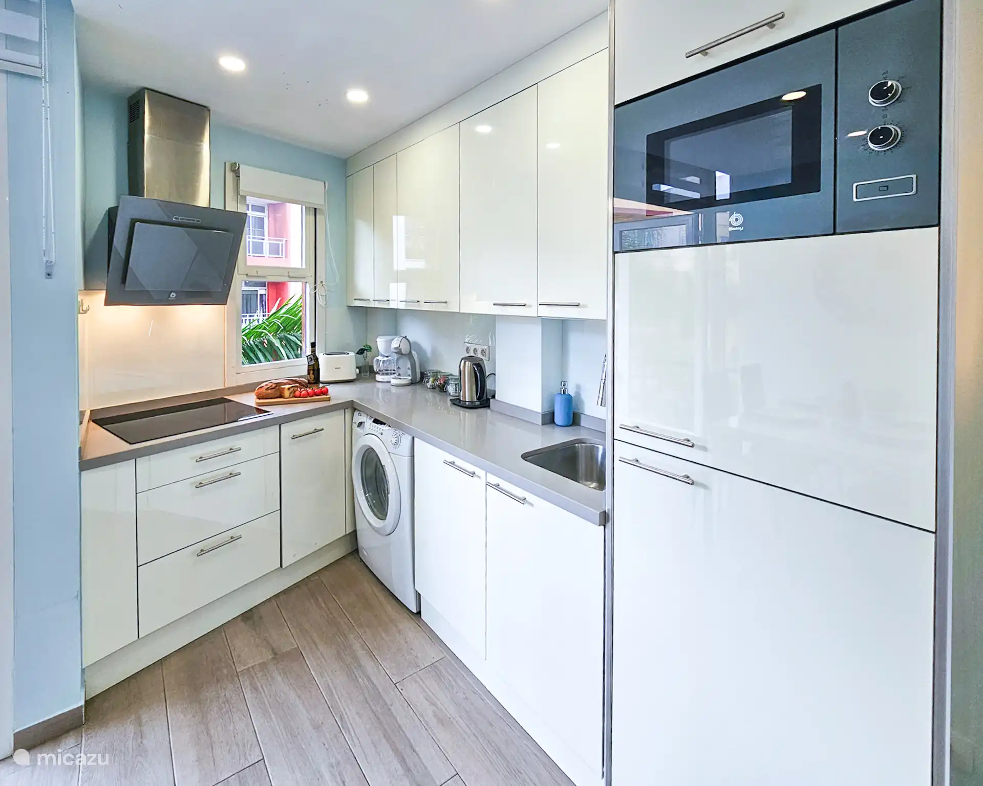 Strakke, volledig uitgeruste keuken met magnetron, koelkast, vriezer, wasmachine en inductiekookplaat. Inclusief waterkoker en Dolce Gusto en filter koffiezetapparaat. 