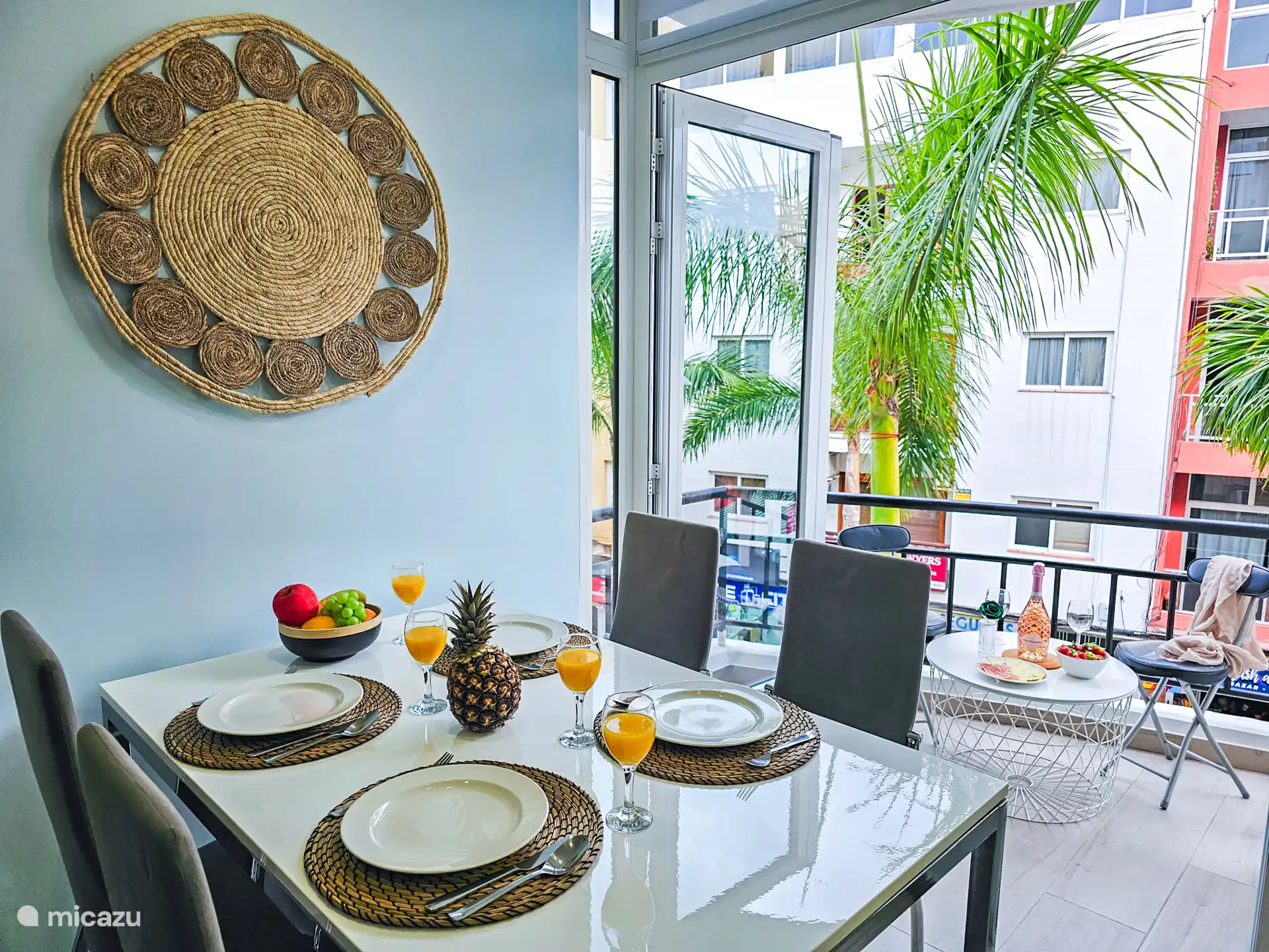 Een ruime eettafel. Grote ramen bieden een prachtig uitzicht op palmbomen. Geniet van gezamenlijke maaltijden in een lichte en uitnodigende ruimte.