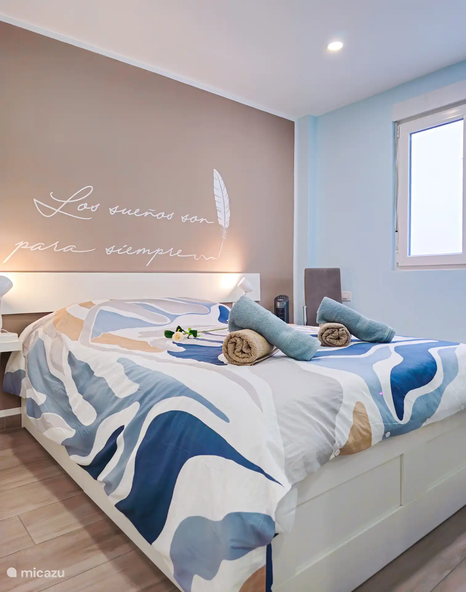 Sfeervolle slaapkamer met tweepersoonsbed, nachtlampjes en zonverduisterende schermen. Ruime kledingkast biedt praktische opbergruimte. Ideaal om te ontspannen na een zonnige dag in Los Cristianos.