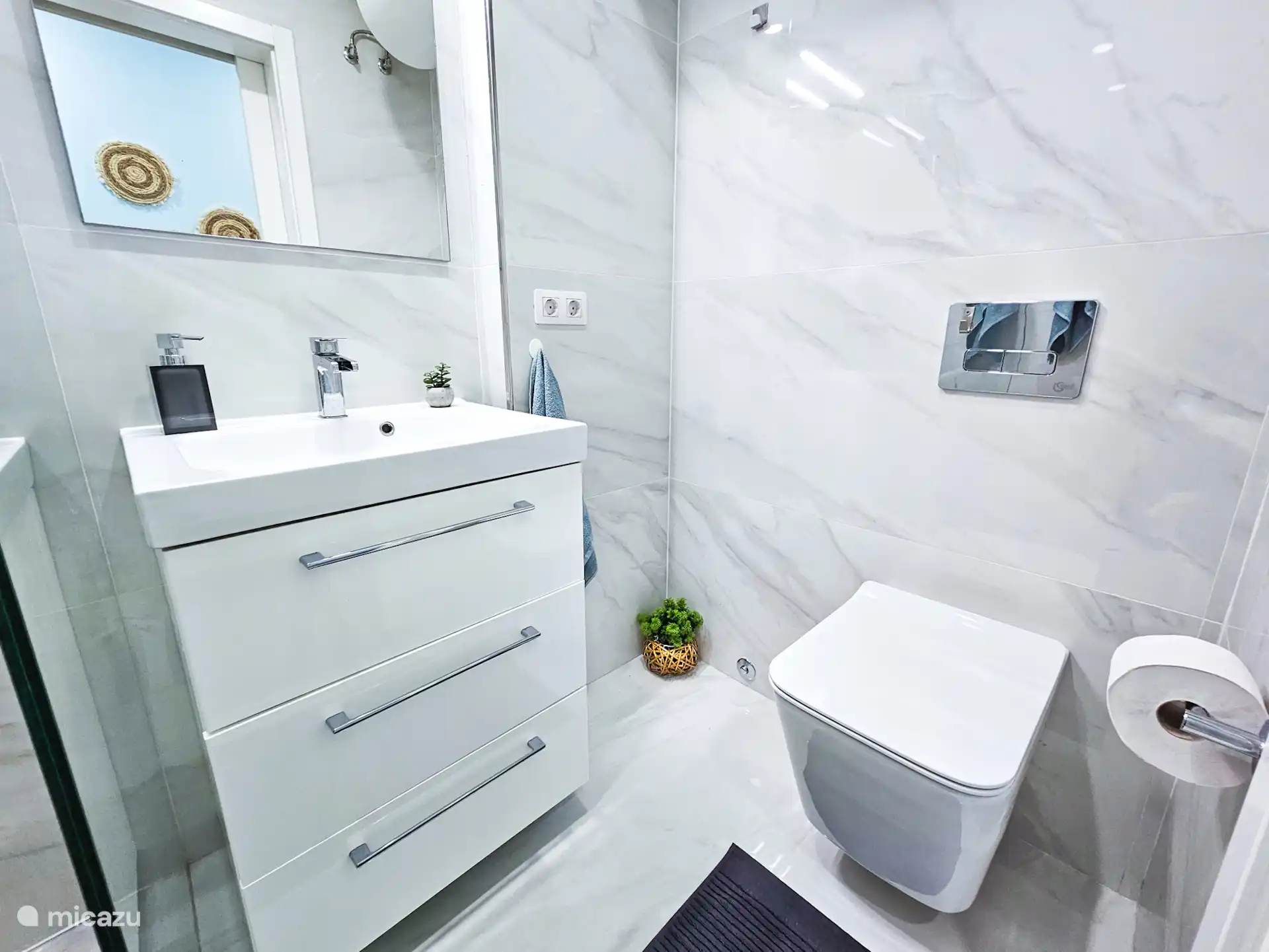 Moderne en strak afgewerkte badkamer met inloopdouche, wastafel en toilet. Fris, licht en van alle gemakken voorzien voor een comfortabel verblijf.