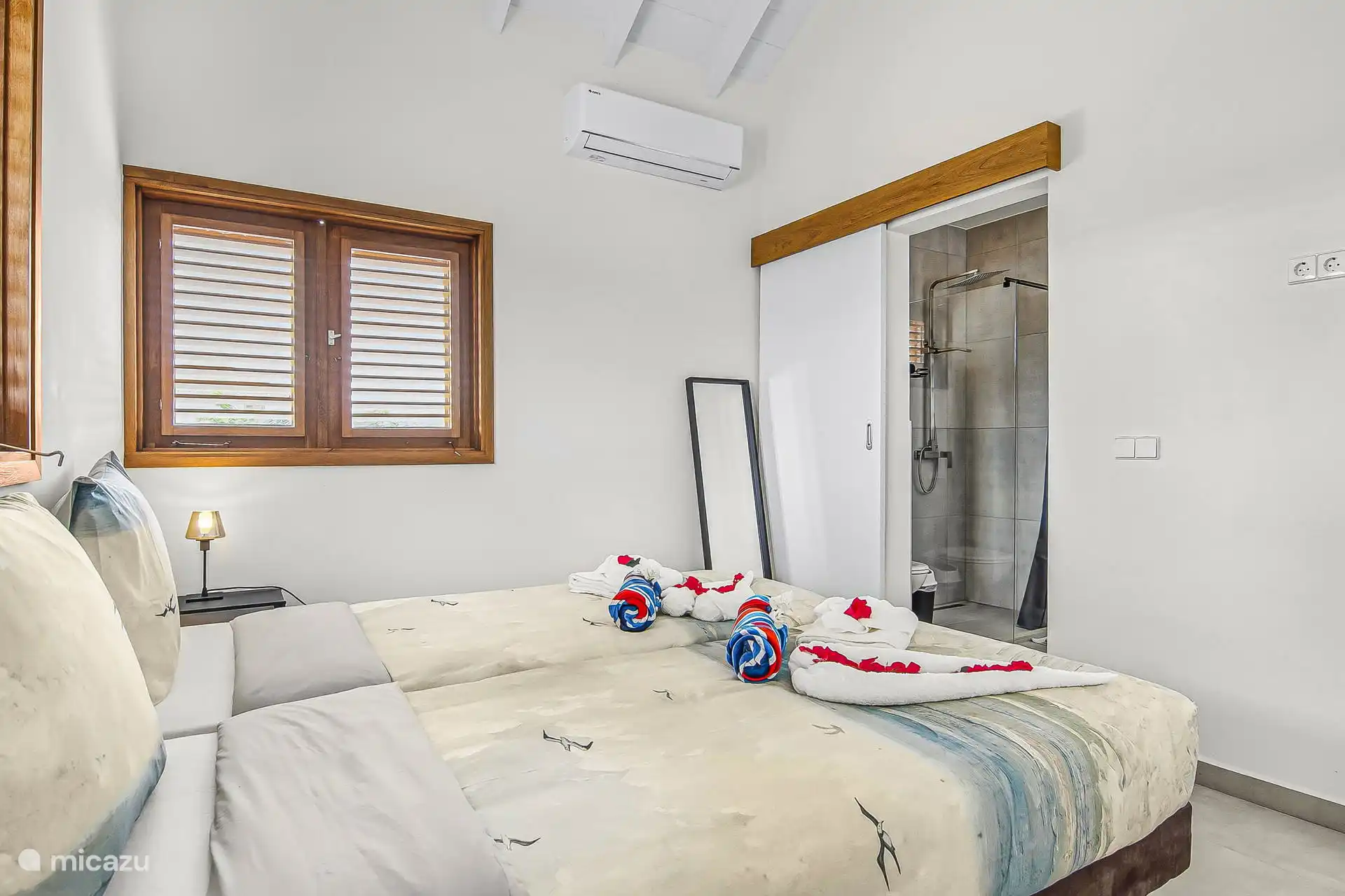 Bedroom with king size bed and access to the bathroom The towels as shown in the photo are provided in the house. So you don't have to take anything with you.