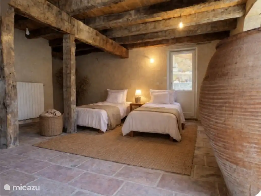 Un dormitorio, dos camas individuales y una cama matrimonial con vistas al jardín.