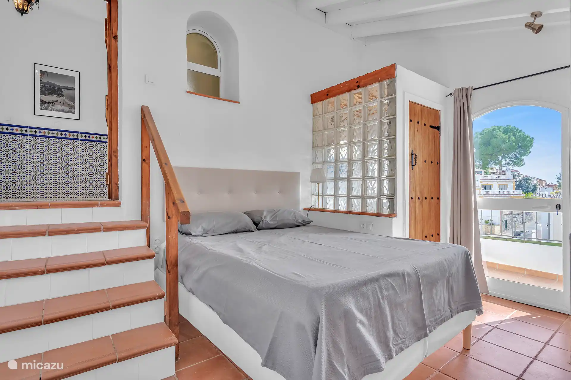 Slaapkamer met queen size bed met toilet, wastafel en douche.