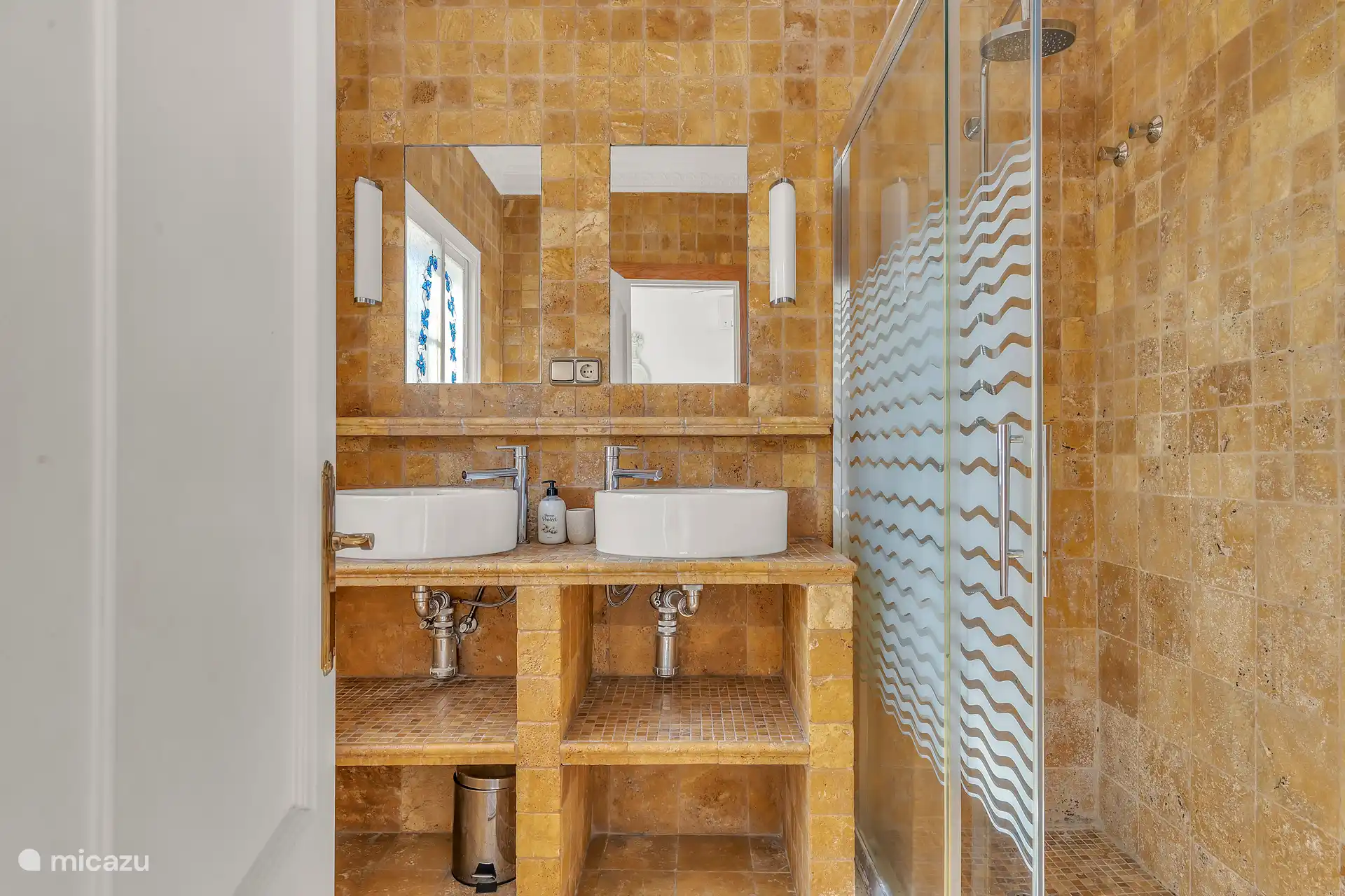 Ensuite badkamer met wastafel en douche.