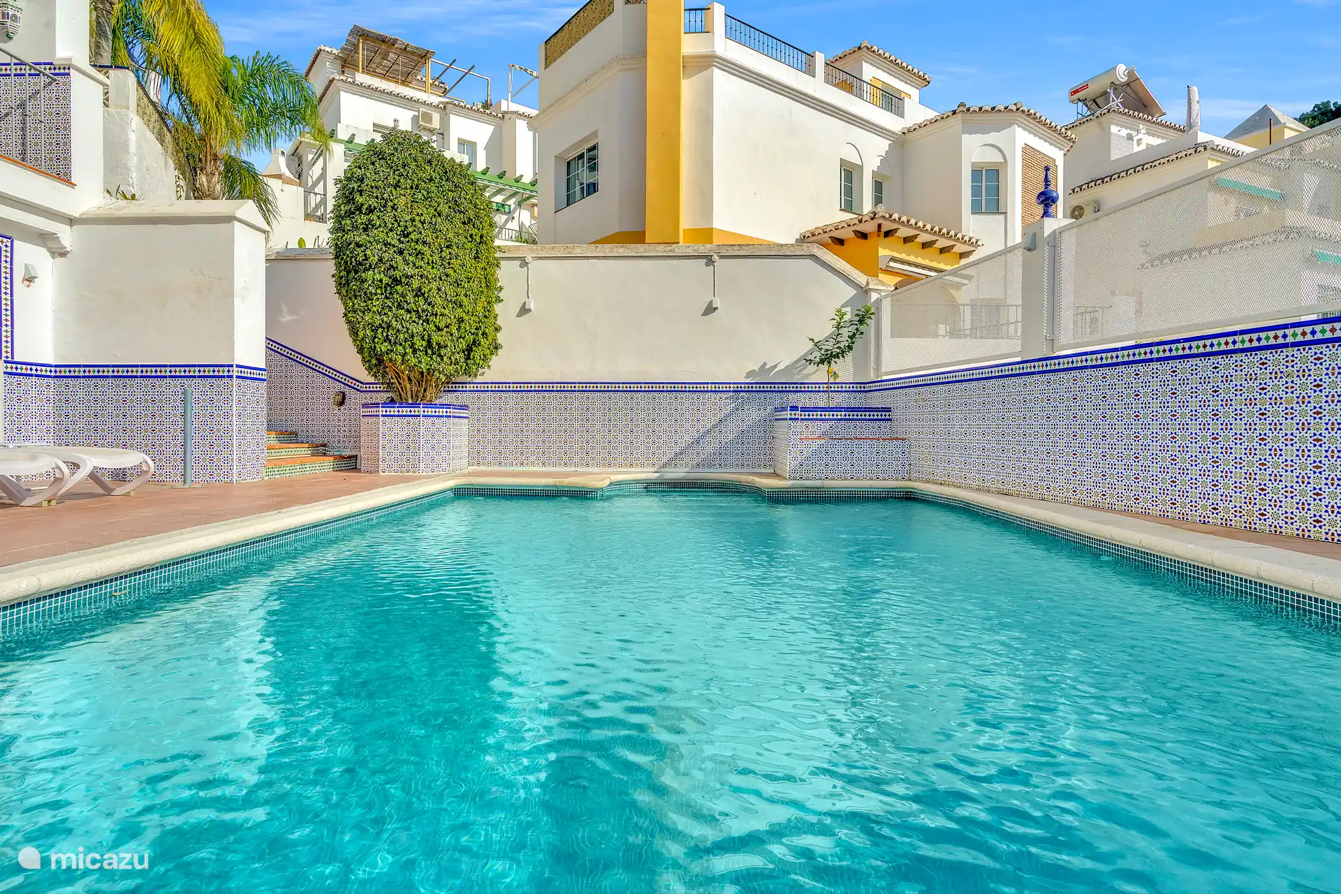 Prive zwembad met ligstoelen