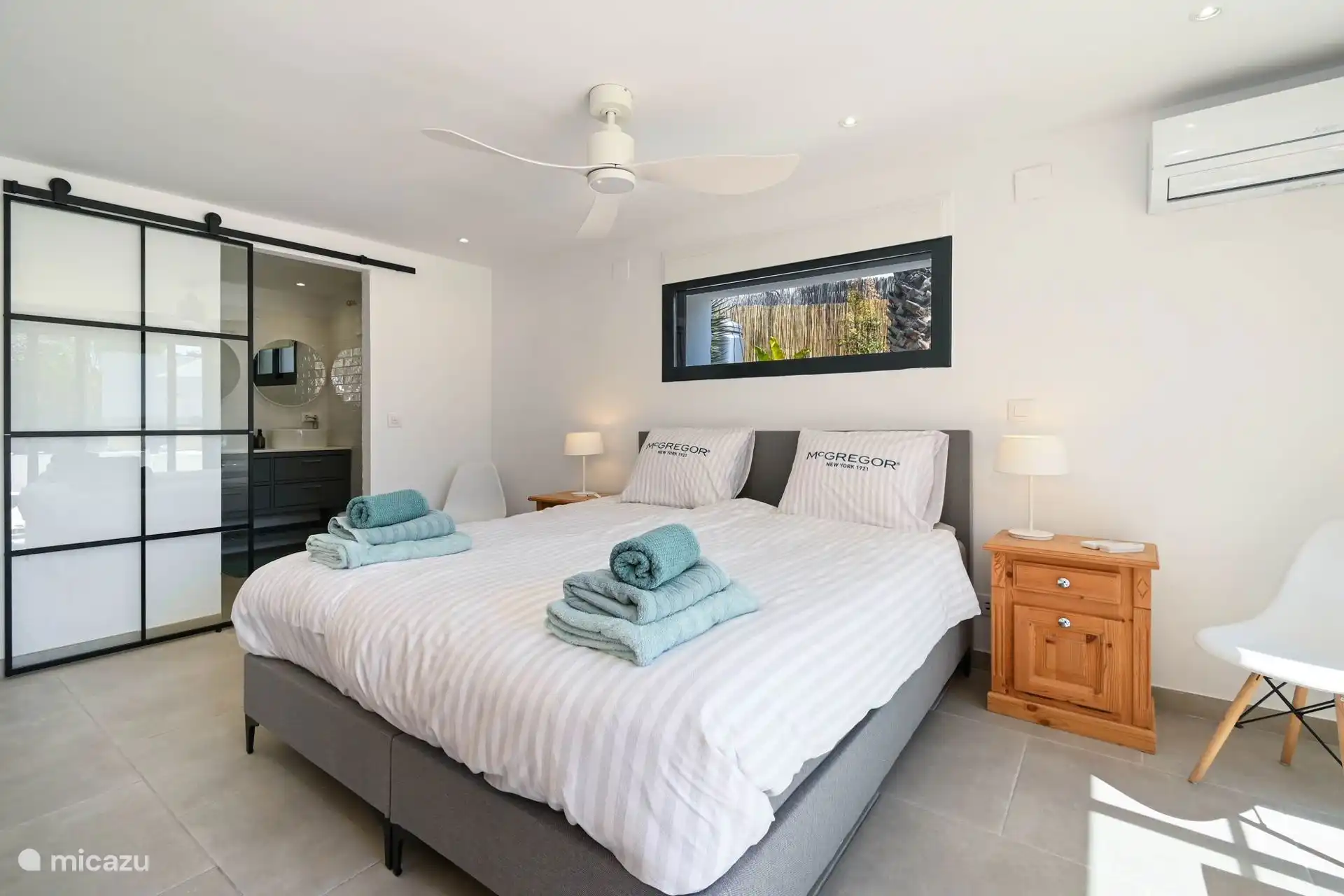 Master bedroom with ensuite bathroom and view of pool terrace