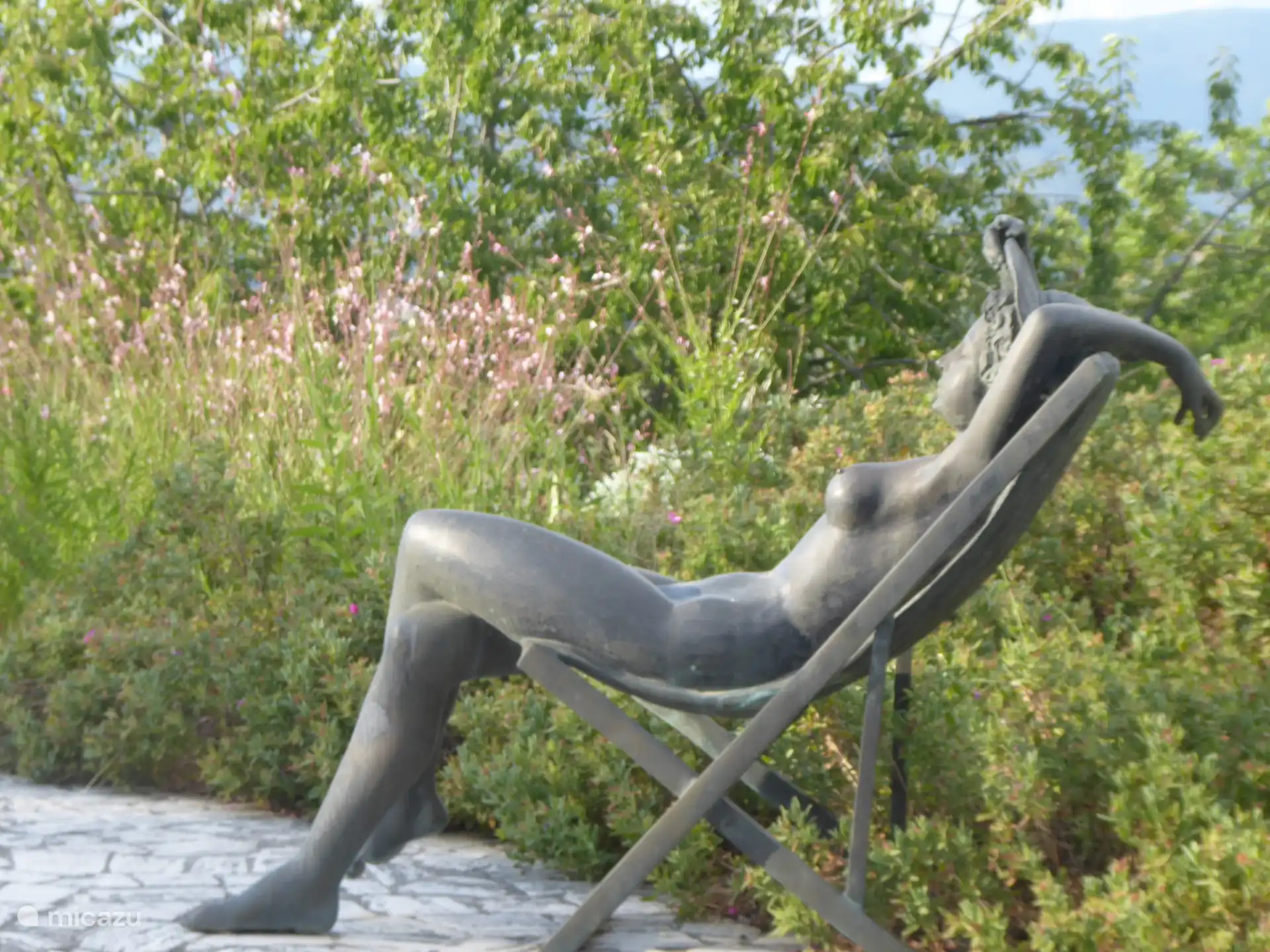 Een bronzen naakt in de zonnen - behalve de hoed.