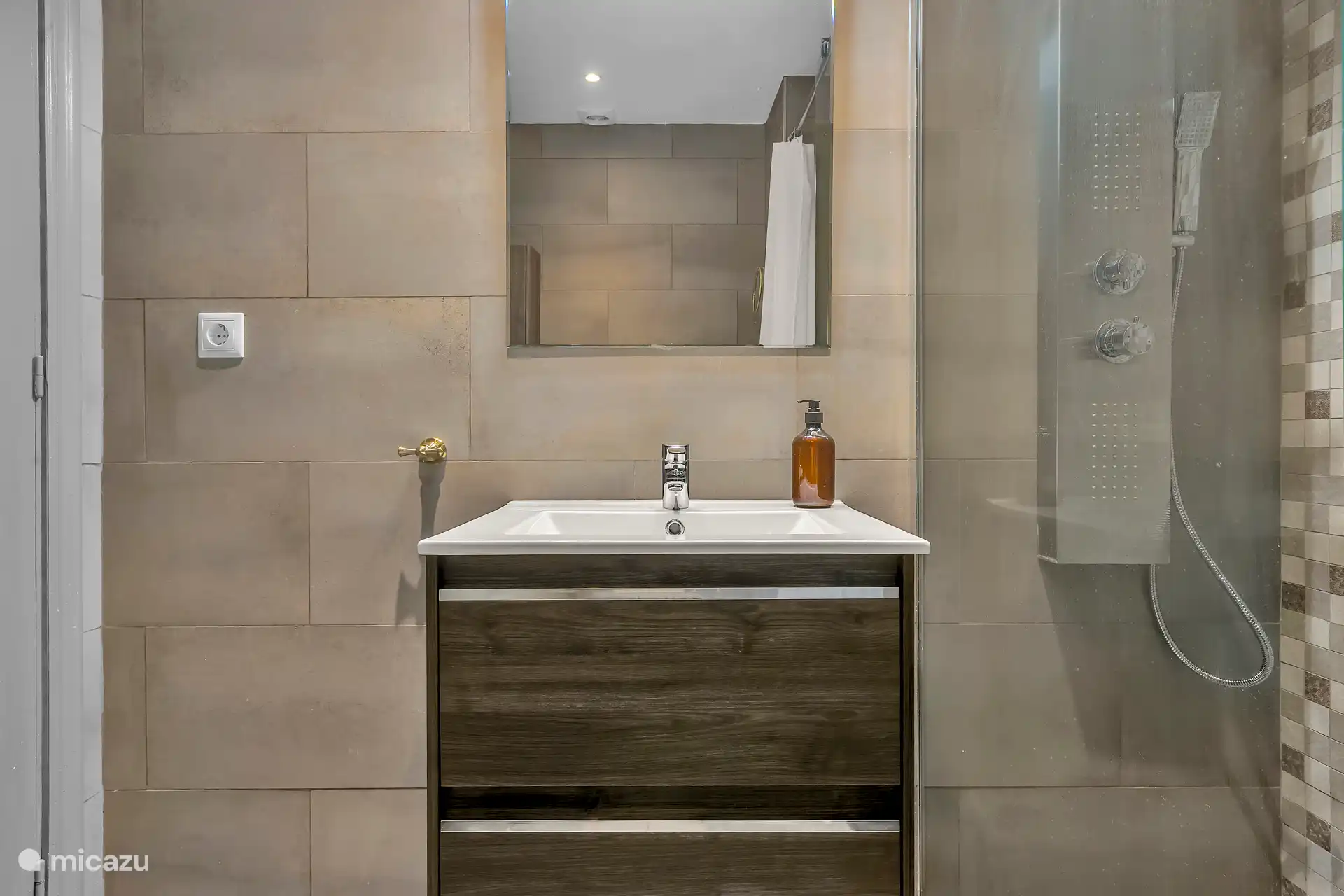 Salle de bain 1 avec massage, douche de pluie et toilettes.