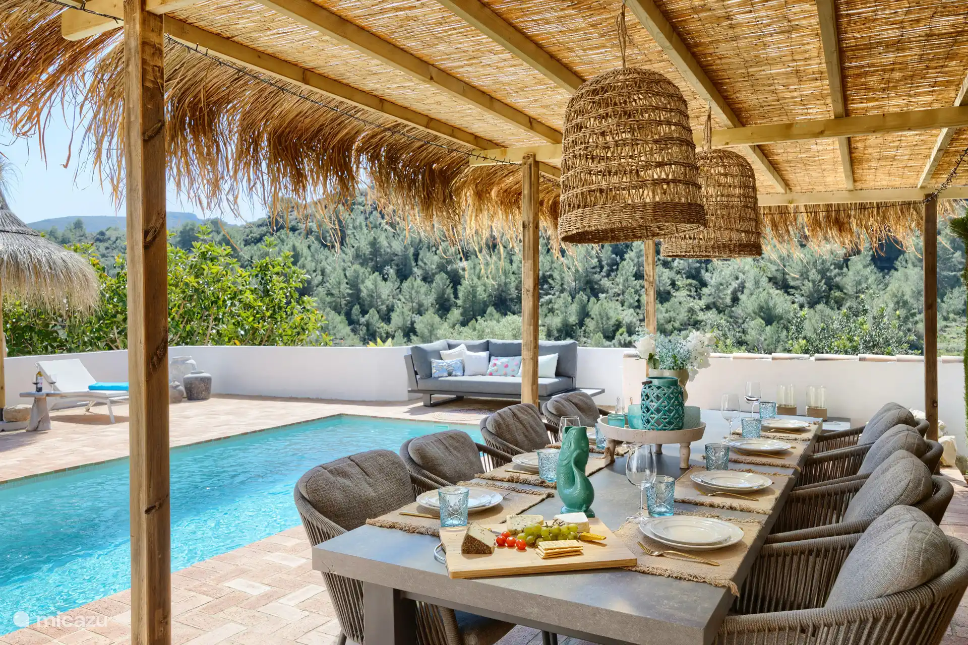 Terrasse am Pool mit großem Esstisch mit 8 Stühlen und einem Lounge-Sofa