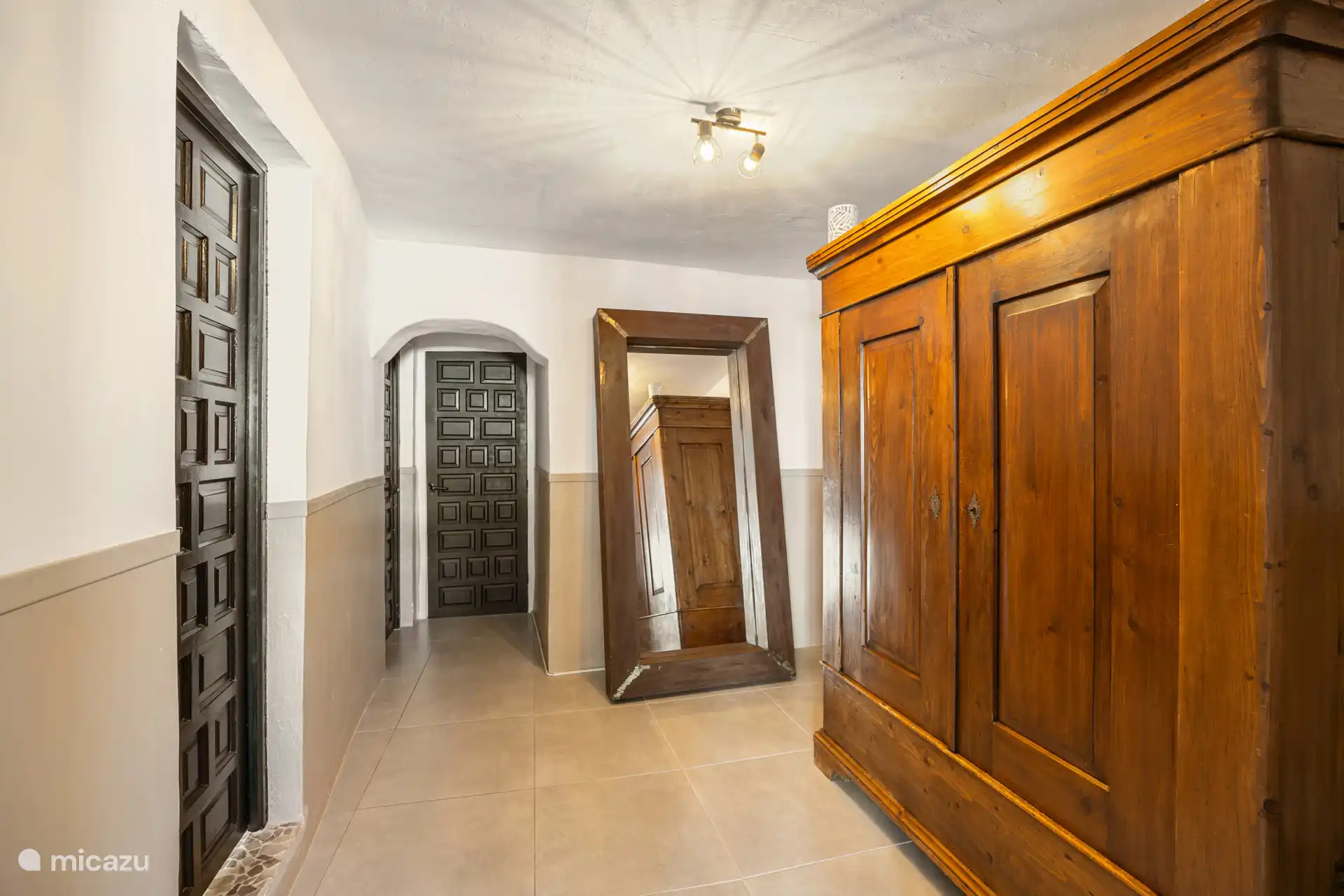 Der Flur, gesehen vom Hauptschlafzimmer aus, mit der Tür zum Badezimmer links und der Tür zum Wohnzimmer weiter vorne.