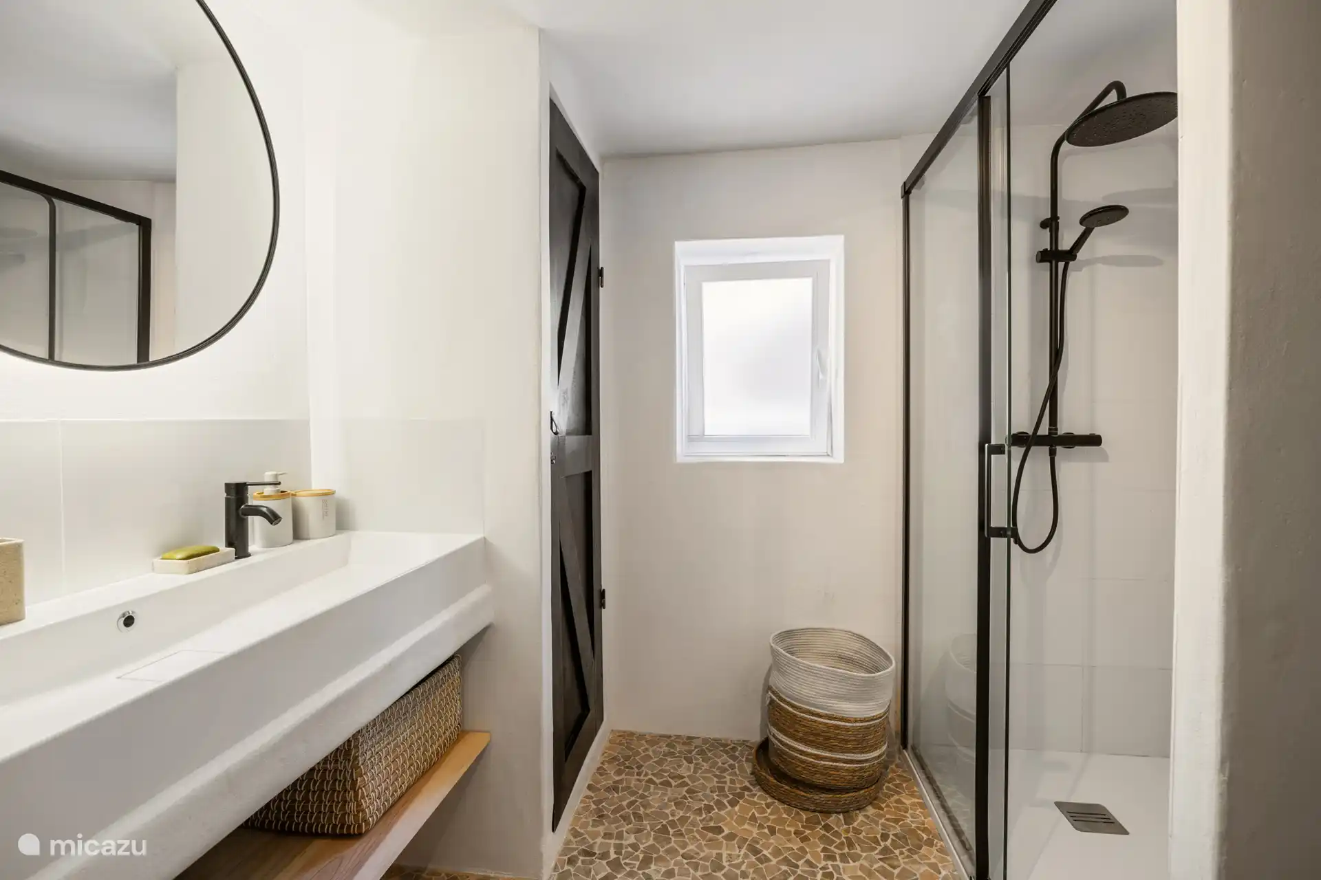 Das Badezimmer gehört zum Hauptwohnhaus mit begehbarer Dusche, geräumigem Doppelwaschbecken und Toilette.