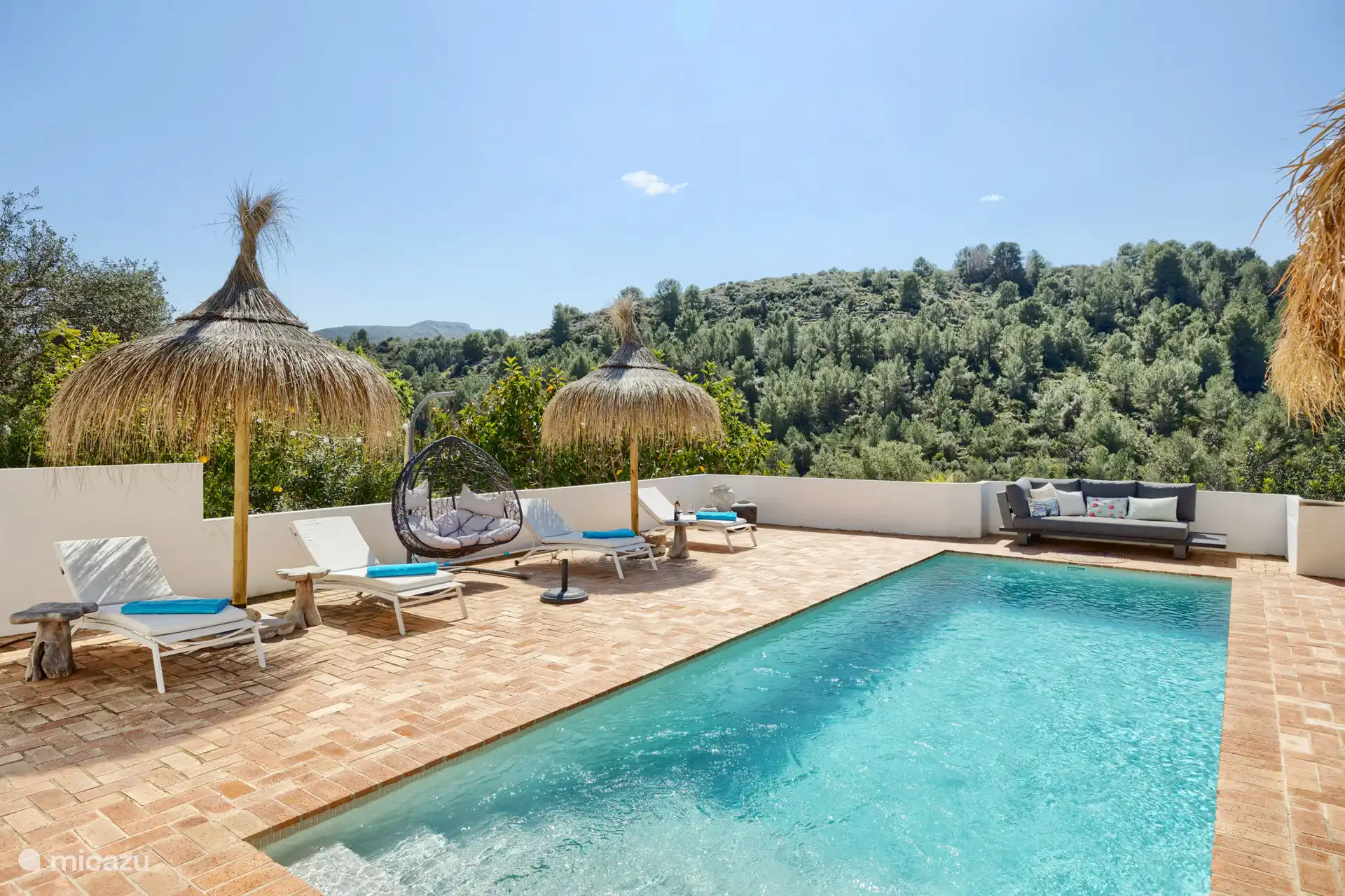 Schwimmbecken mit Sonnenliegern, Hängestuhl und Liegecouch