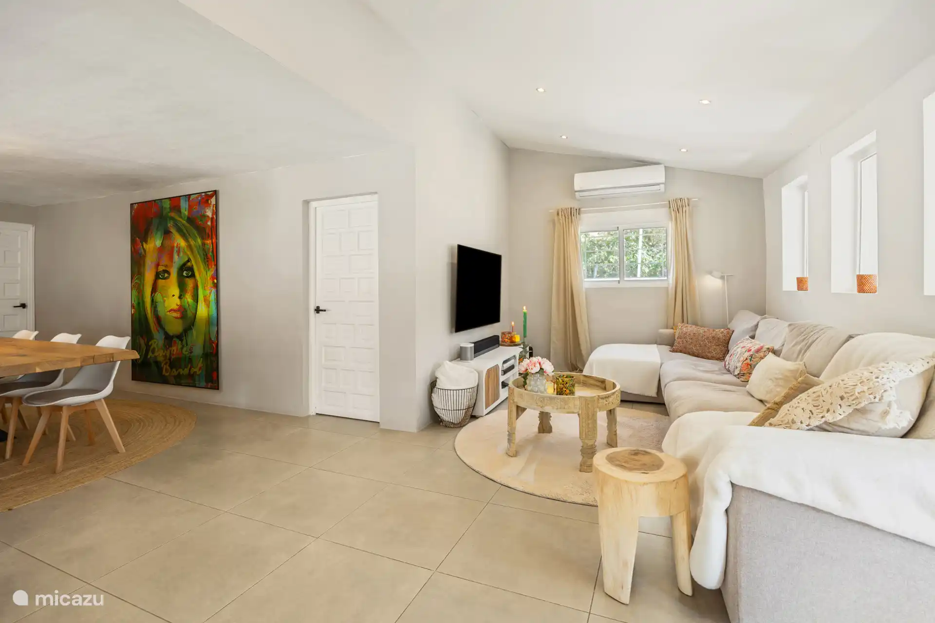 Sitzbereich mit Fernseher und Tür zu einem Schlafzimmer