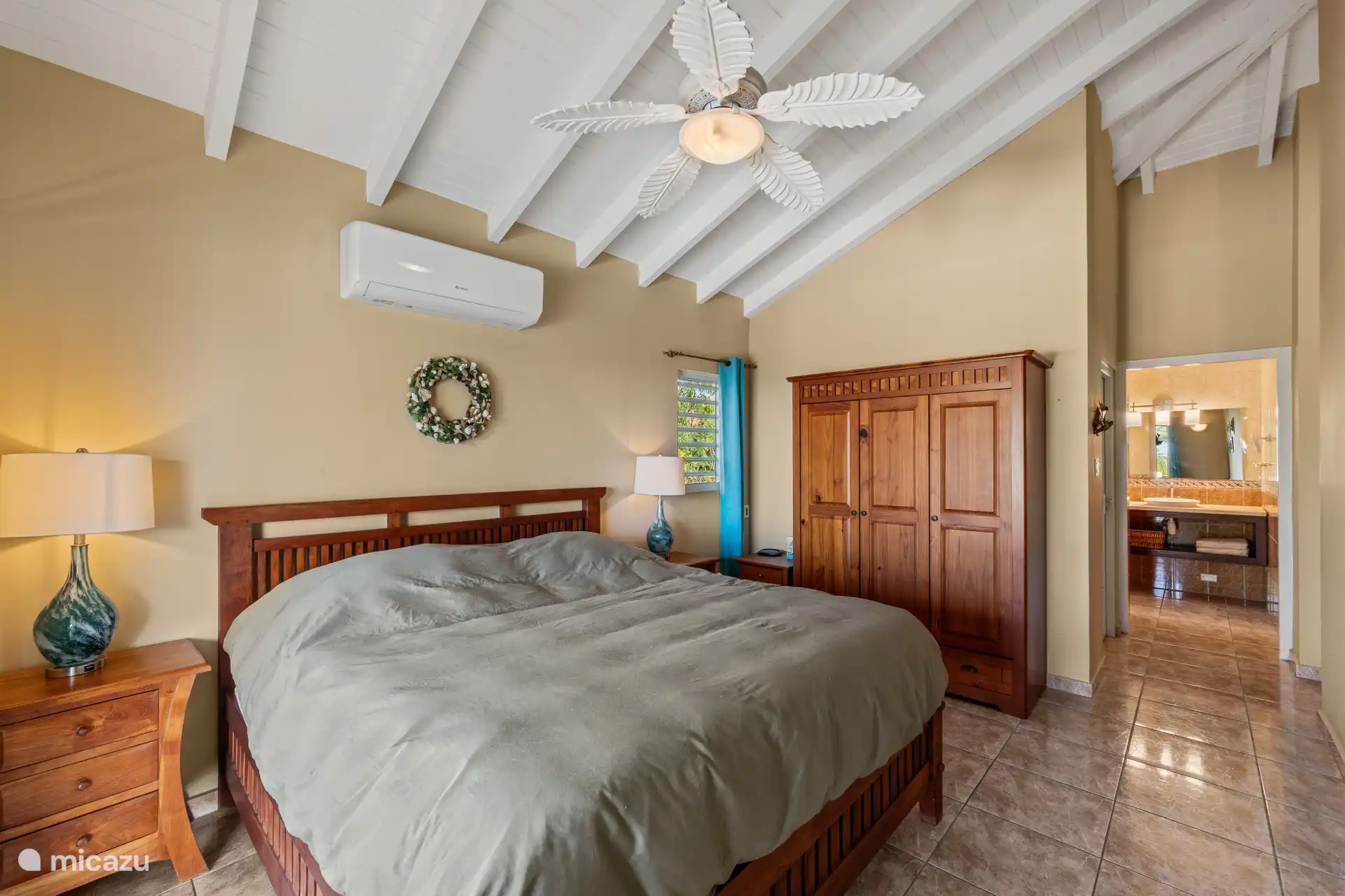 Ruime master slaapkamer met openslaande deuren, bergruimte waar heel veel spullen in liggen die gebruikt mogen worden.