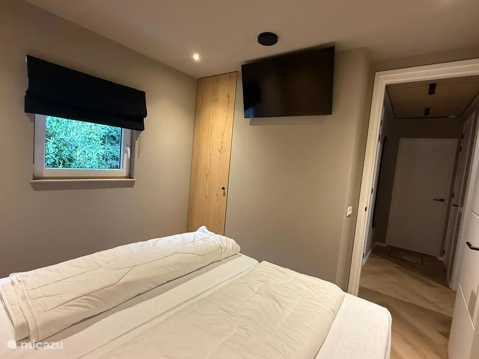 Ouderslaapkamer met smart televisie en grote inbouwkast. 