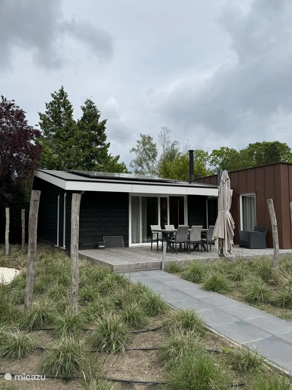 Op het terras aan de voorkant is een ruime tafel en een relaxed lounche gedeelte