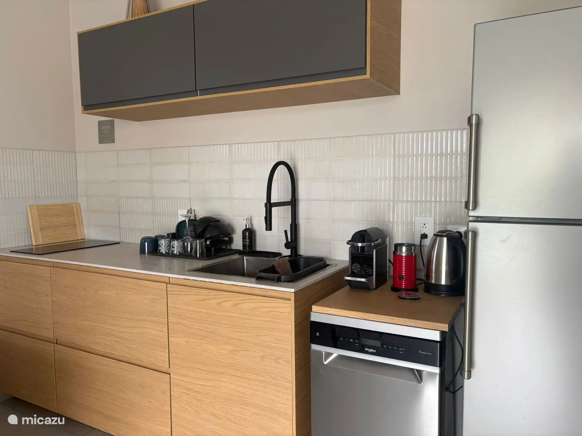 Een volledig uitgeruste keuken met koelkast, vriesvak, inductiekookplaat, airfryer, waterkoker, Nespresso-machine en vaatwasser.