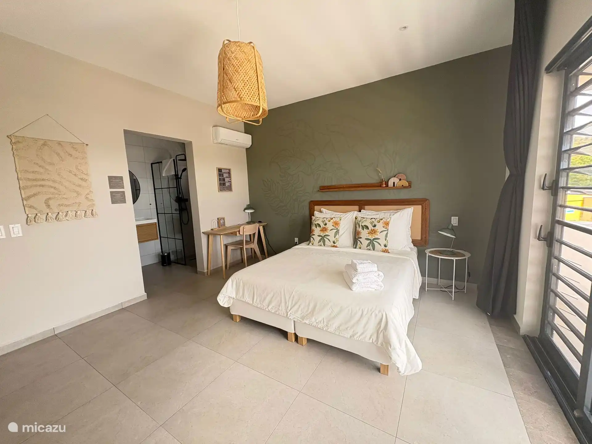 Op de eerste etage vindt u een comfortabele slaapkamer met airco, een queen size bed en een moderne ensuite badkamer met douche en wastafel.