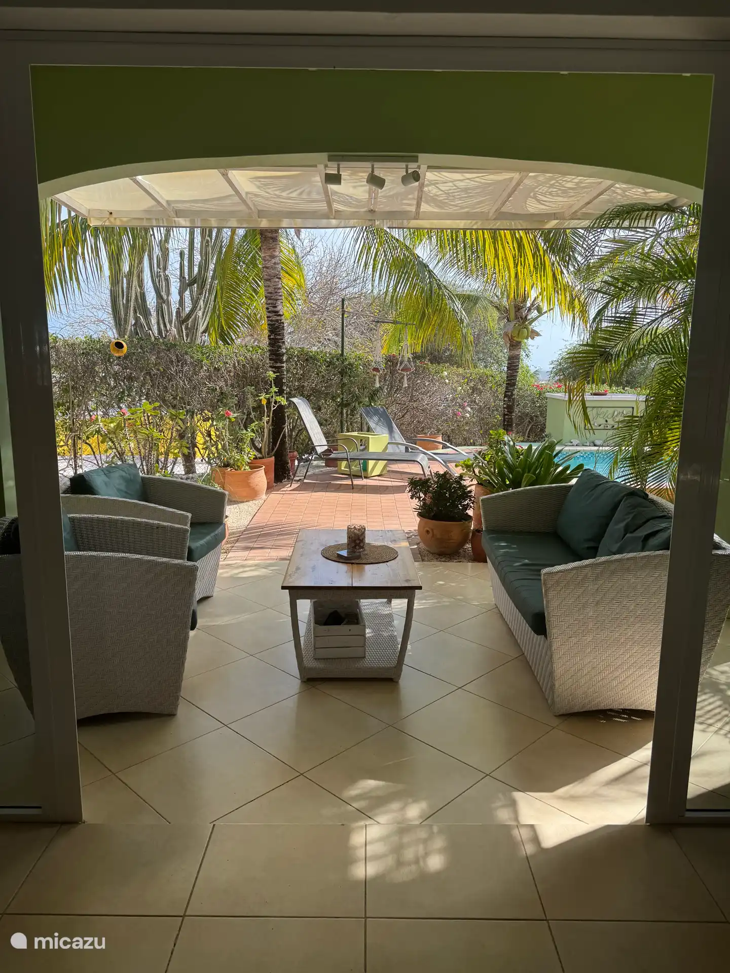 Overdekt terras met zwembad en ligstoelen