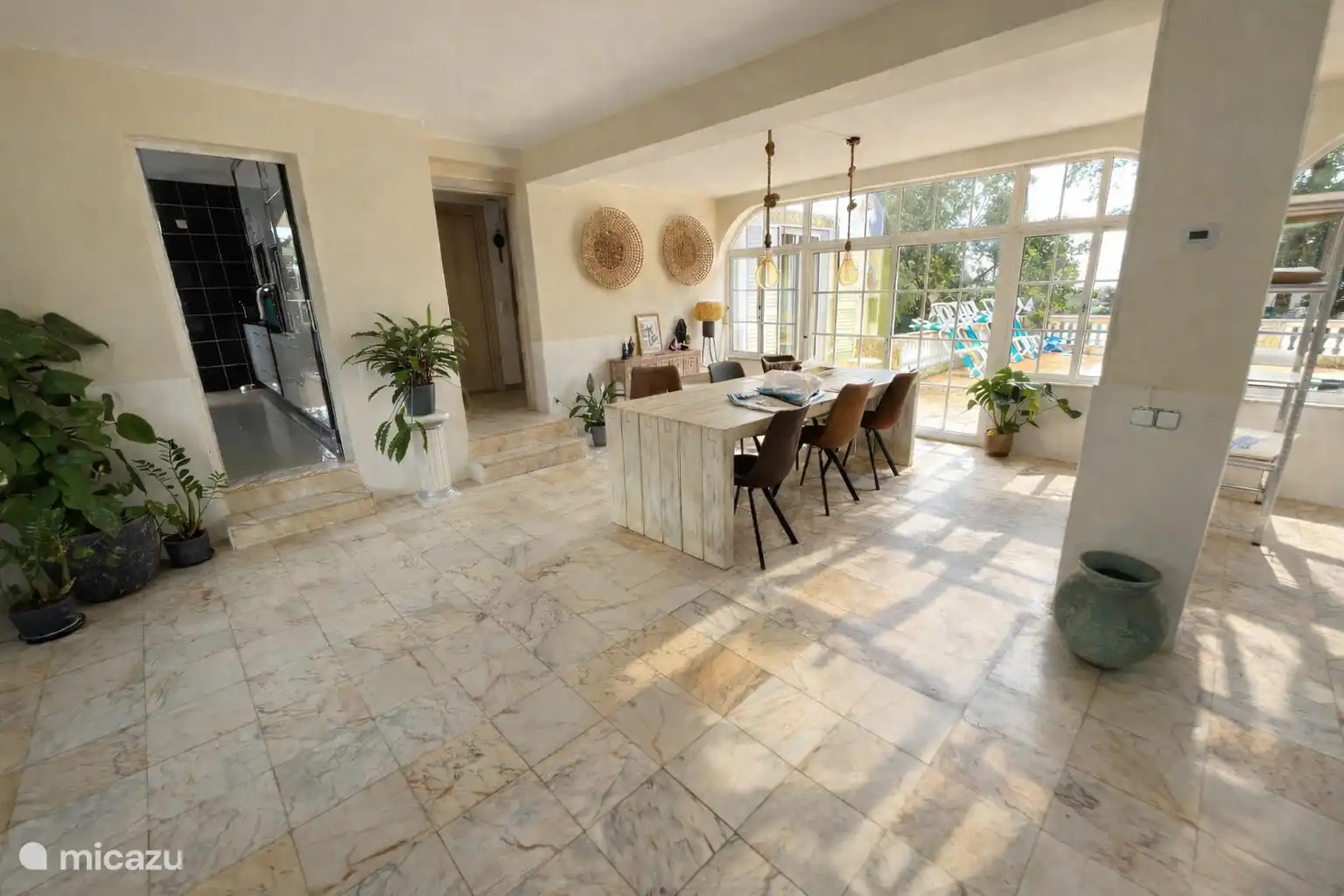 Le côté gauche du salon avec la table à manger et la porte coulissante donnant sur la piscine.