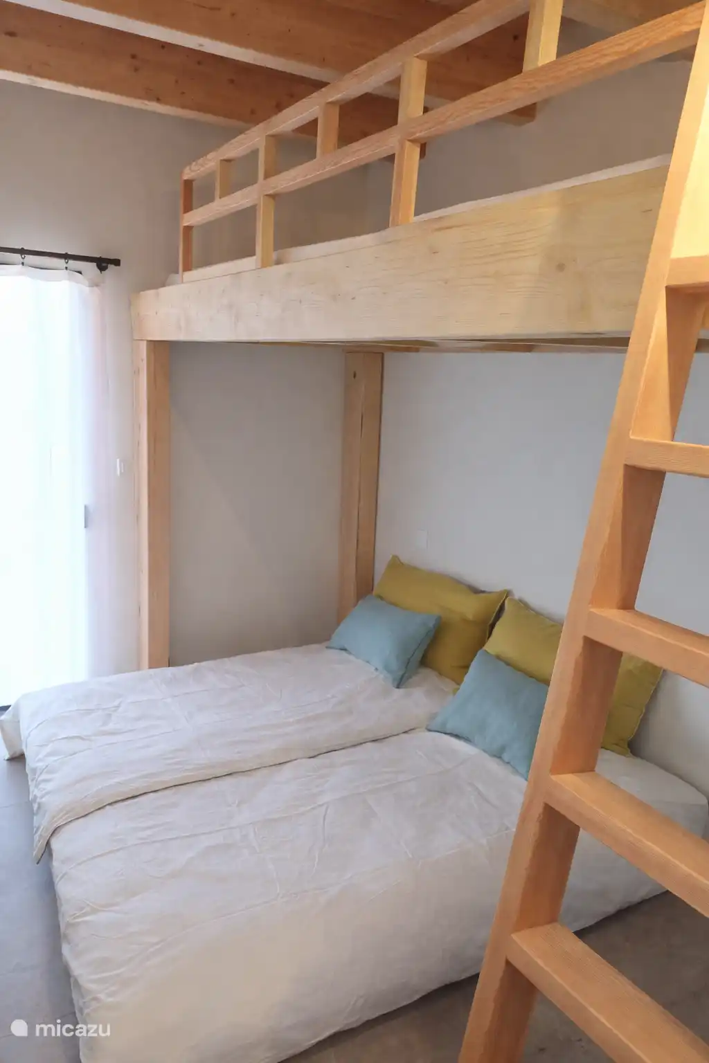Slaapkamer met 4 bedden, waarvan 2 op de mezzanine.