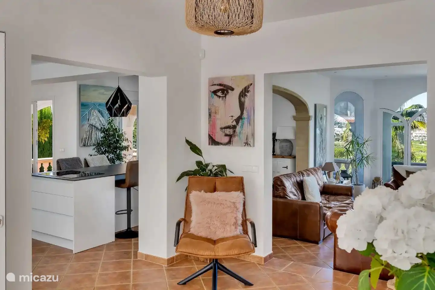 La zona de estar fluye muy bien y es muy abierta. Esto muestra el vestíbulo de entrada con la cocina y el comedor, además de la zona de estar. 