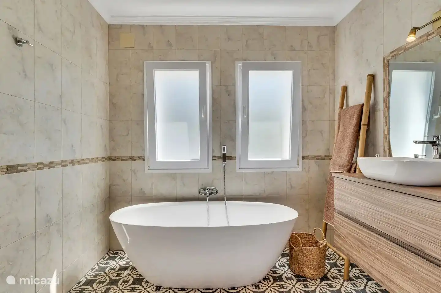 Baño principal en suite con baño independiente, lavabo doble y ducha a nivel de cama.