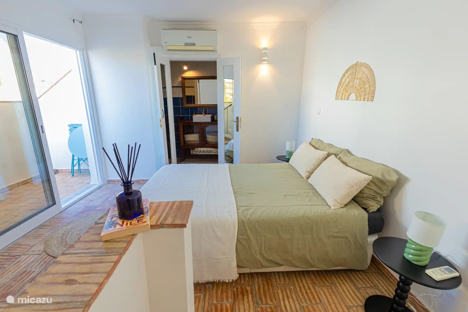 Second bedroom with ensuite bathroom and stairs leading towards the rooftop terrace.