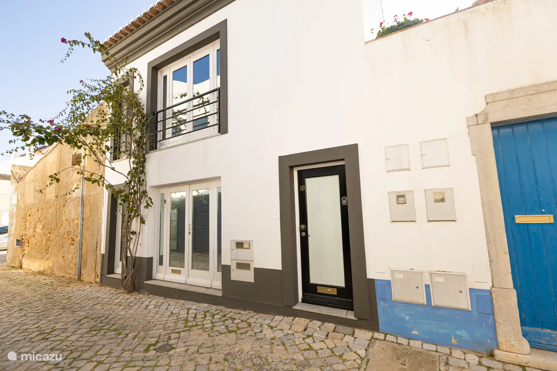 Front of the property. In a calm street, with few cars passing. 