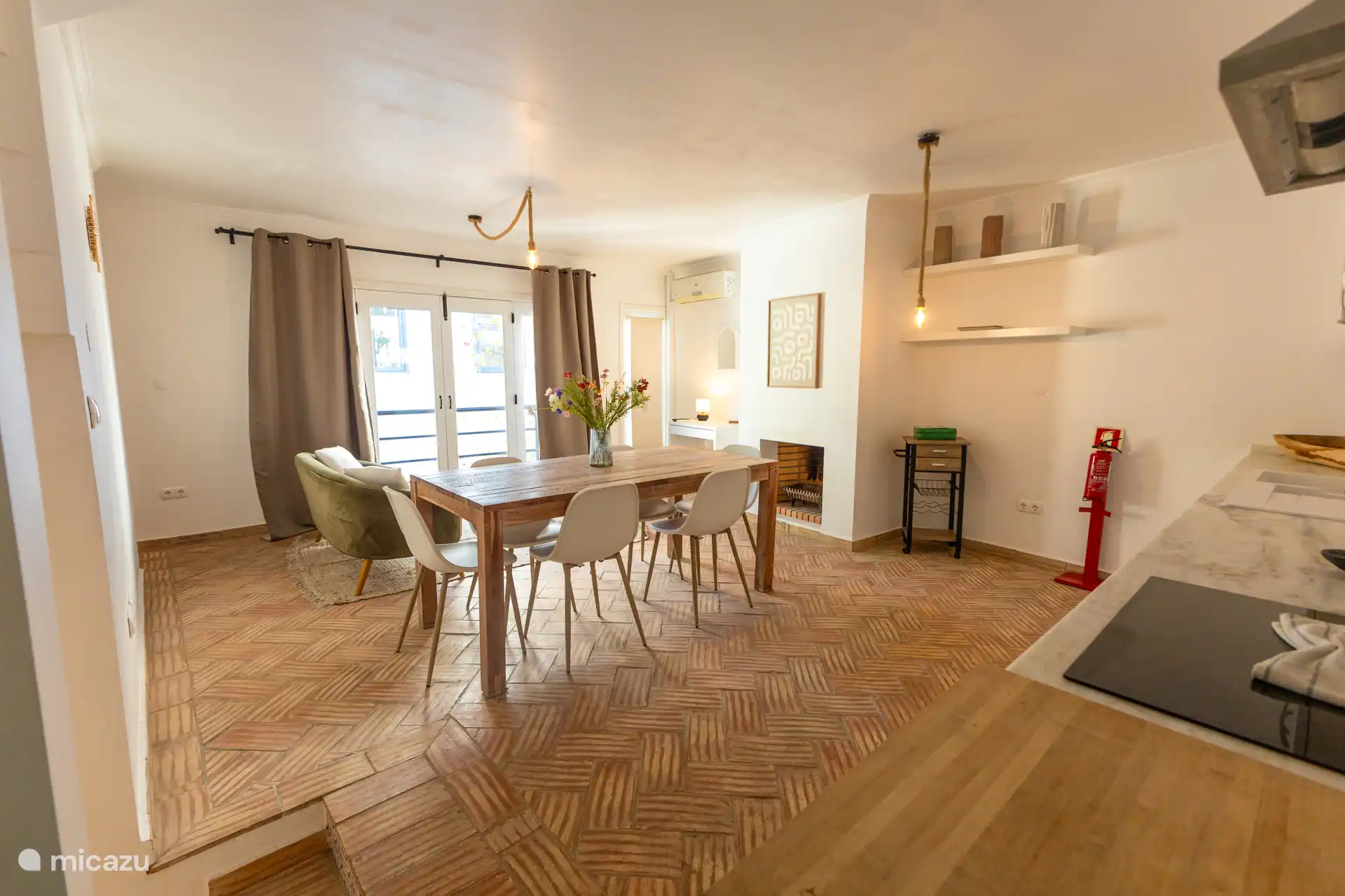 Living room with couch and dining table. Kitchen with induction. 