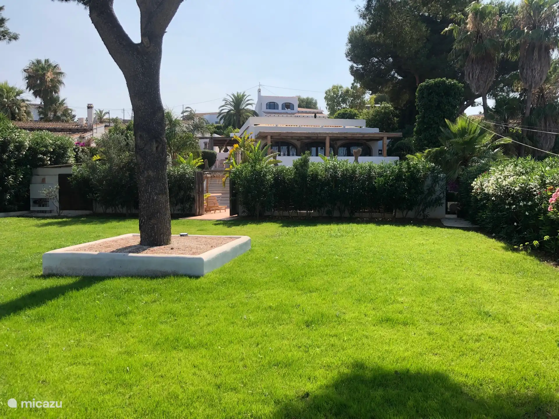 Ruime tuin met groot grasveld, in de achtegrond Casa Monte Feliz 