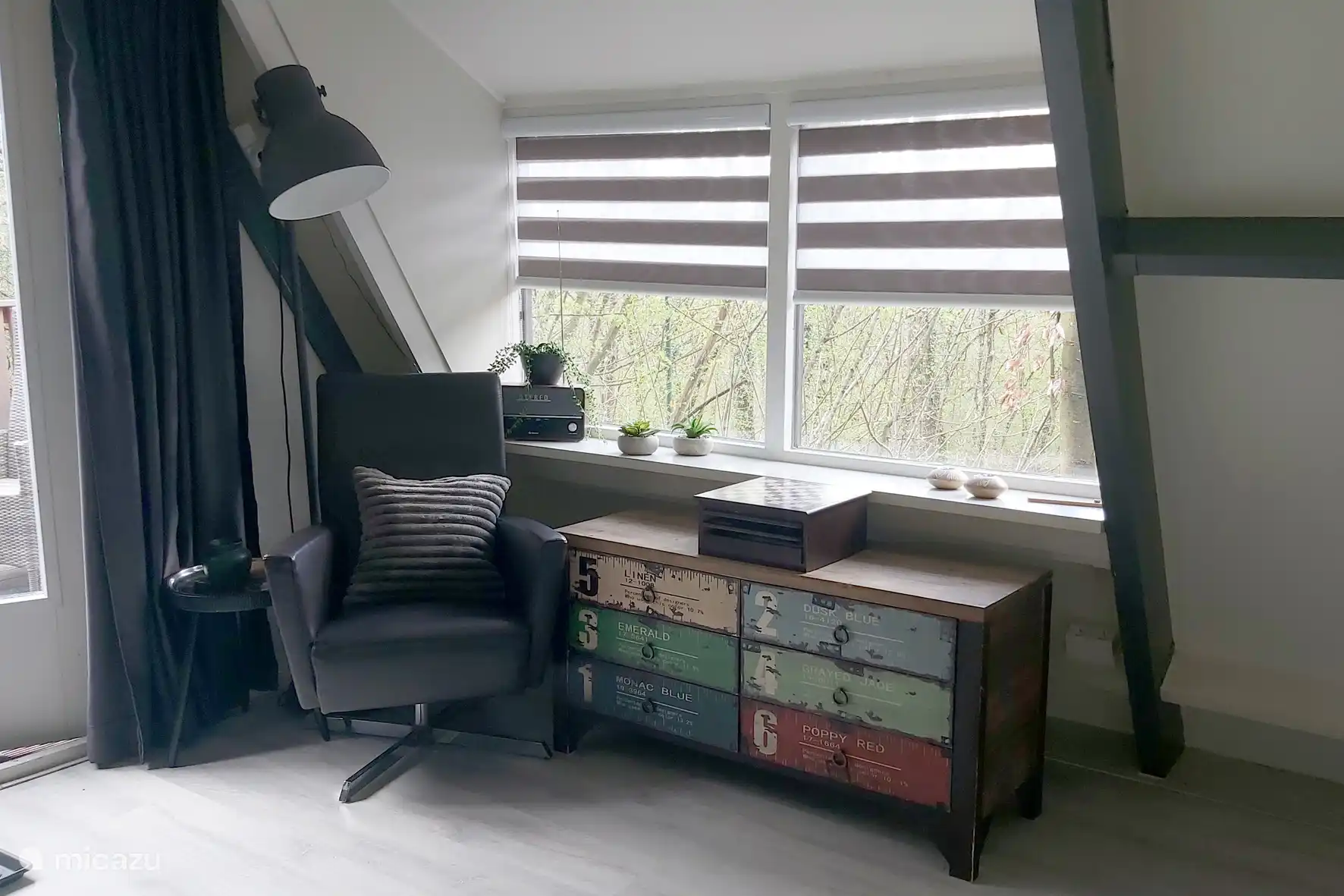 Coin assis/détente avec une commode remplie de livres, de brochures, de jeux de société, de tissus à colorier, etc.