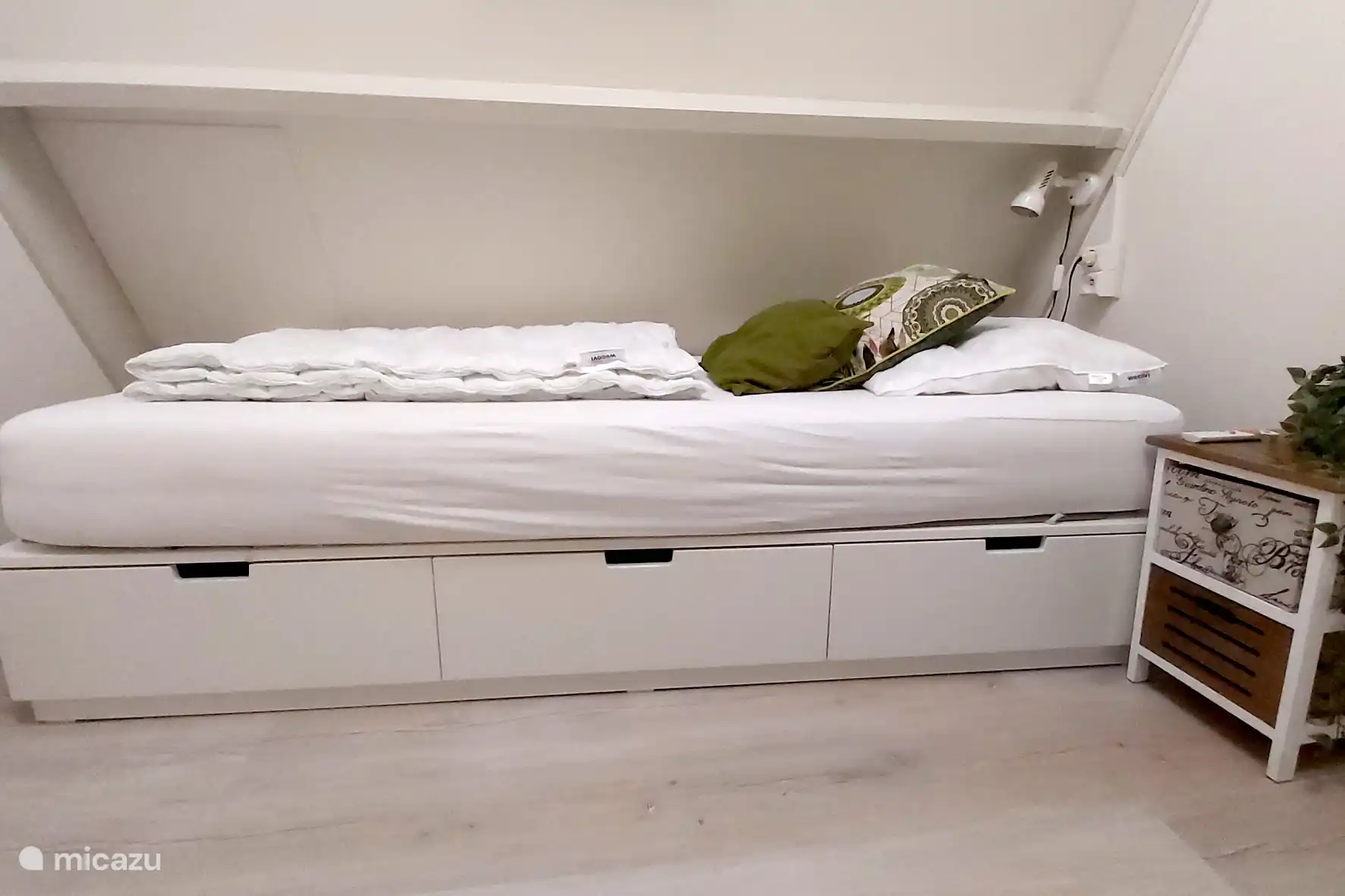 Un lit simple sur le palier. Il est équipé de 3 tiroirs sous le lit pour stocker le matériel.