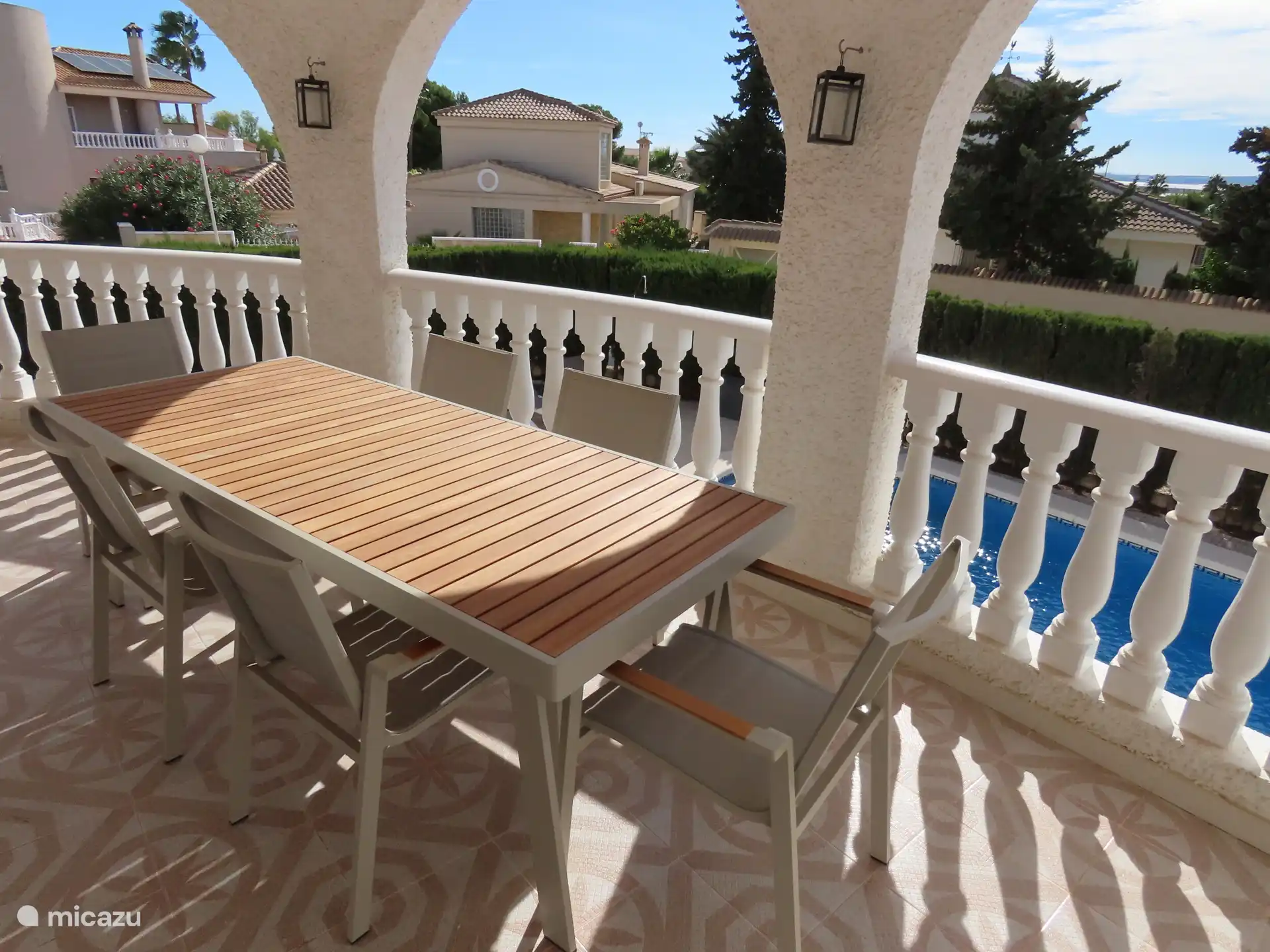 Grote overdekte veranda met eetgelegenheid.