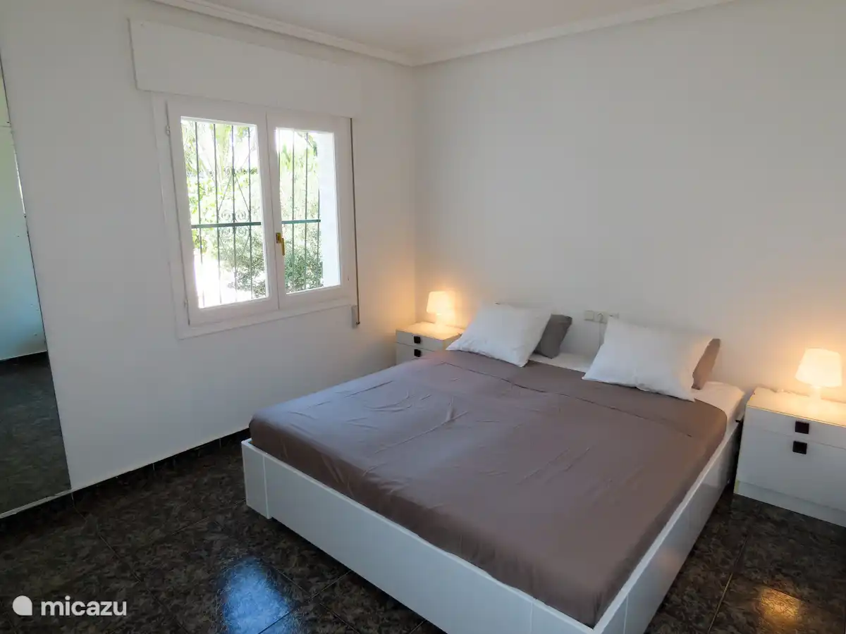 Slaapkamer met ruim tweepersoonsbed en inbouwkasten